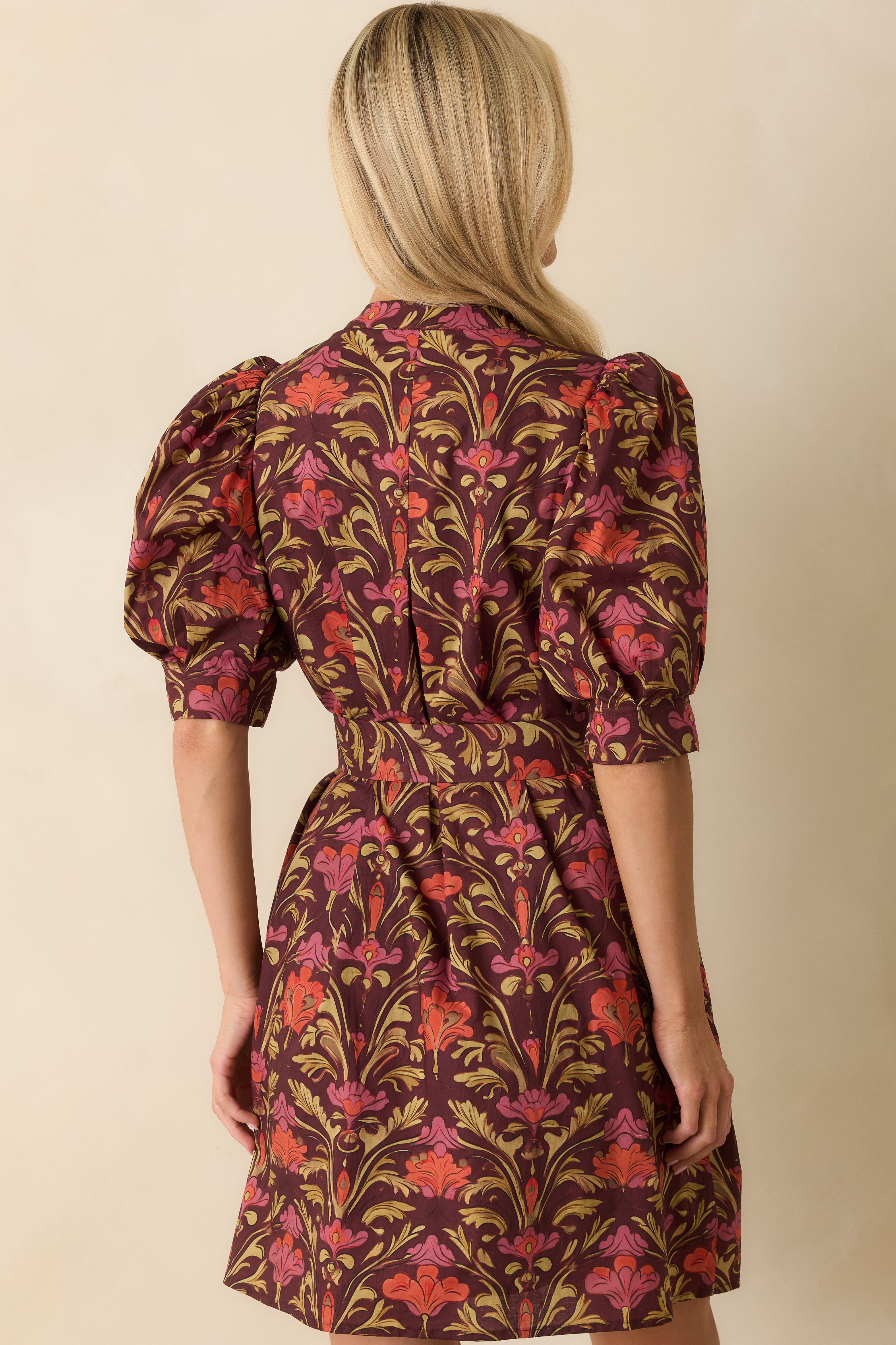 Back view of the mini dress displaying the belt tie at the back and the continuous floral print.