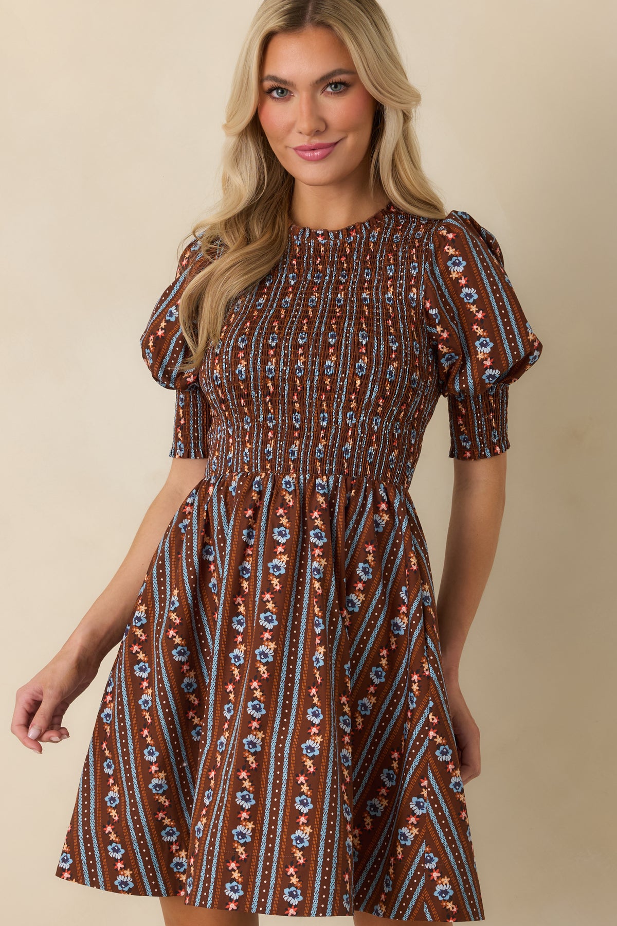 Floral mini dress highlighting the removable tie belt and comfortably smocked waist before the skirt flares outward.