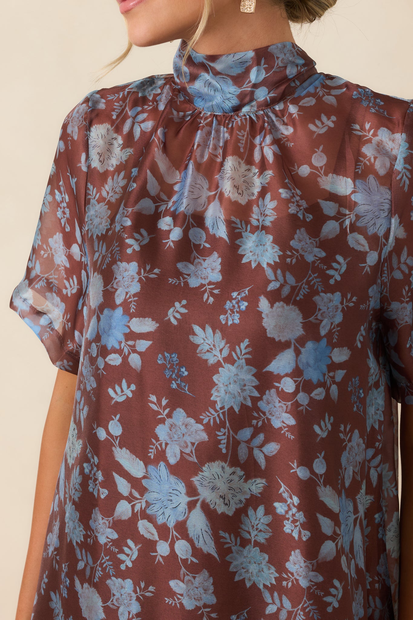 Close-up view of the floral maxi dress highlighting the sheer printed overlay, neckline tie, and textured layered details.