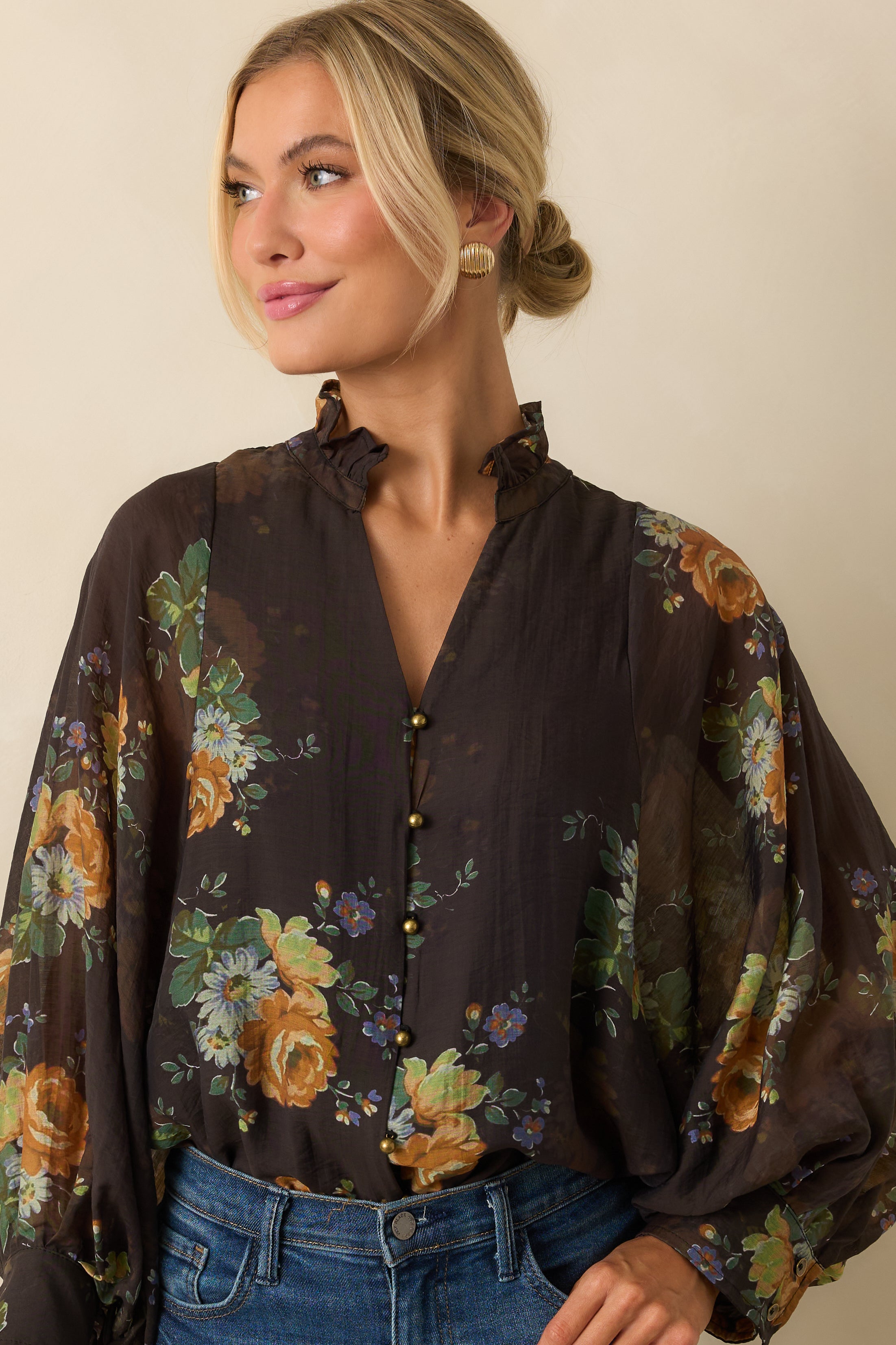 Focus on the floral pattern and relaxed fit across the torso of the blouse.