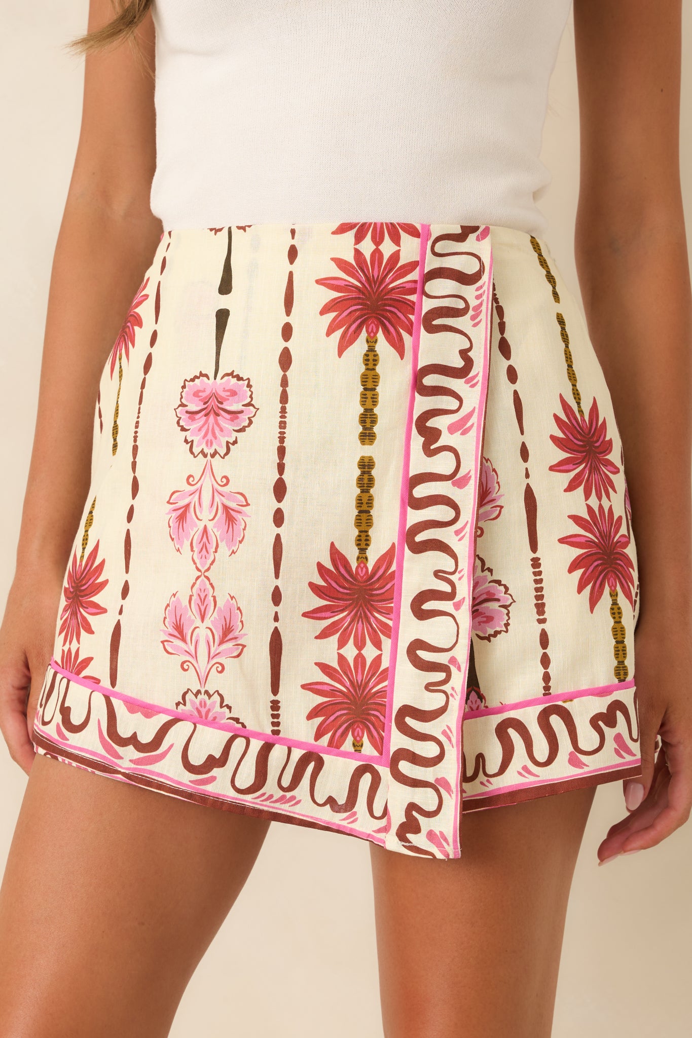 Close-up of the floral cotton-linen fabric highlighting the vibrant pink contrast piping and tailored construction.