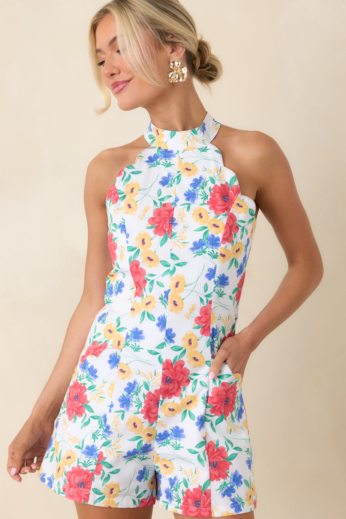 Floral print romper with scalloped trim along neckline.