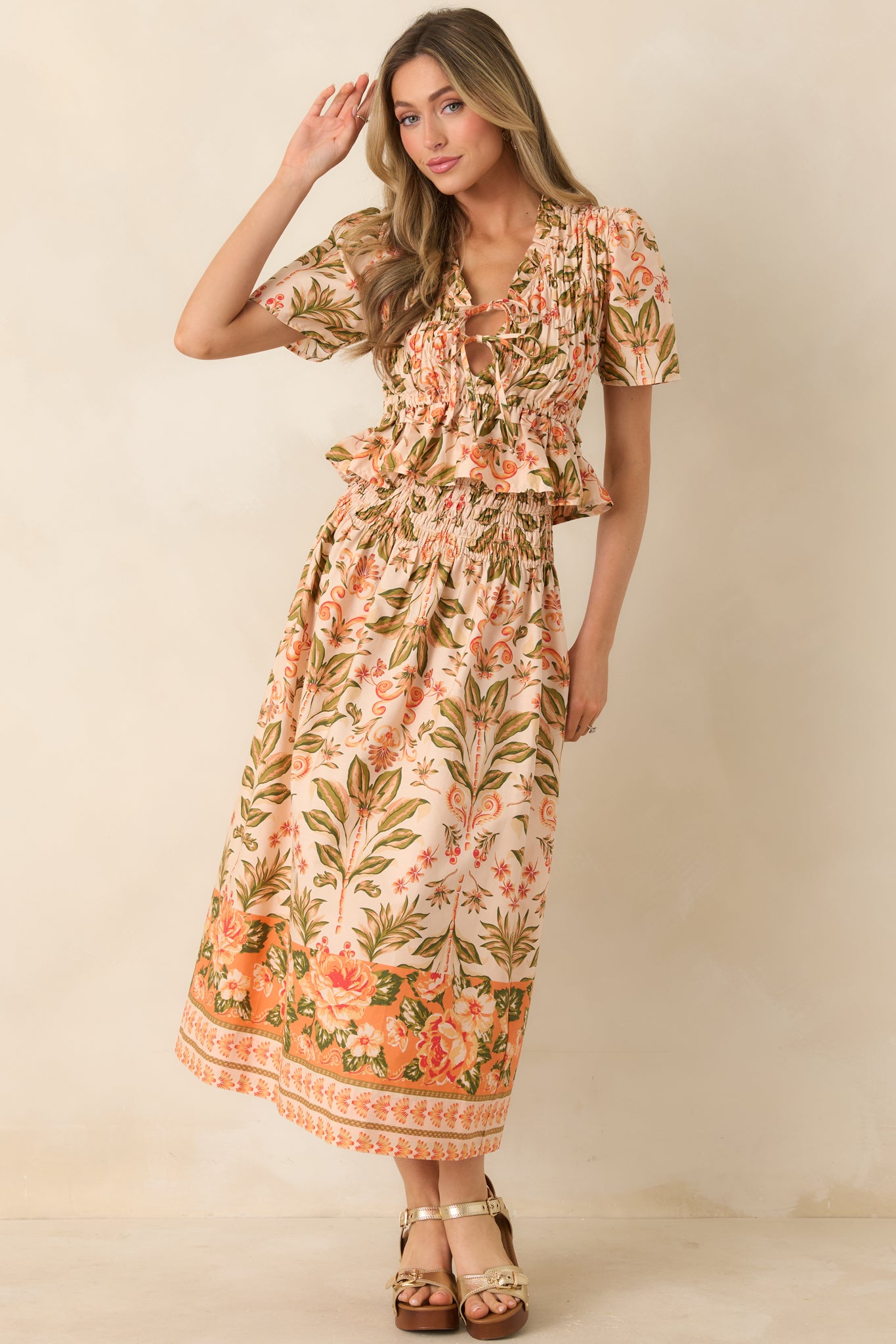 Floral print top featuring elastic smocked fit, short puffed sleeves, and ruffle hem.