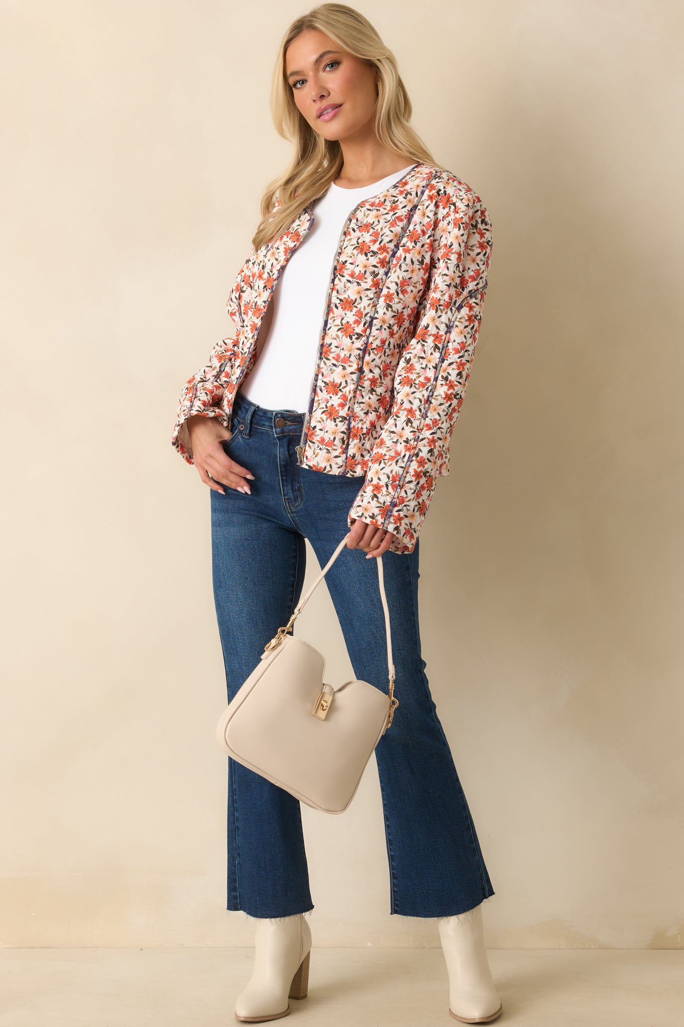 Long-sleeve floral quilted jacket featuring snap-front closures over a hidden zipper and contrast piping.
