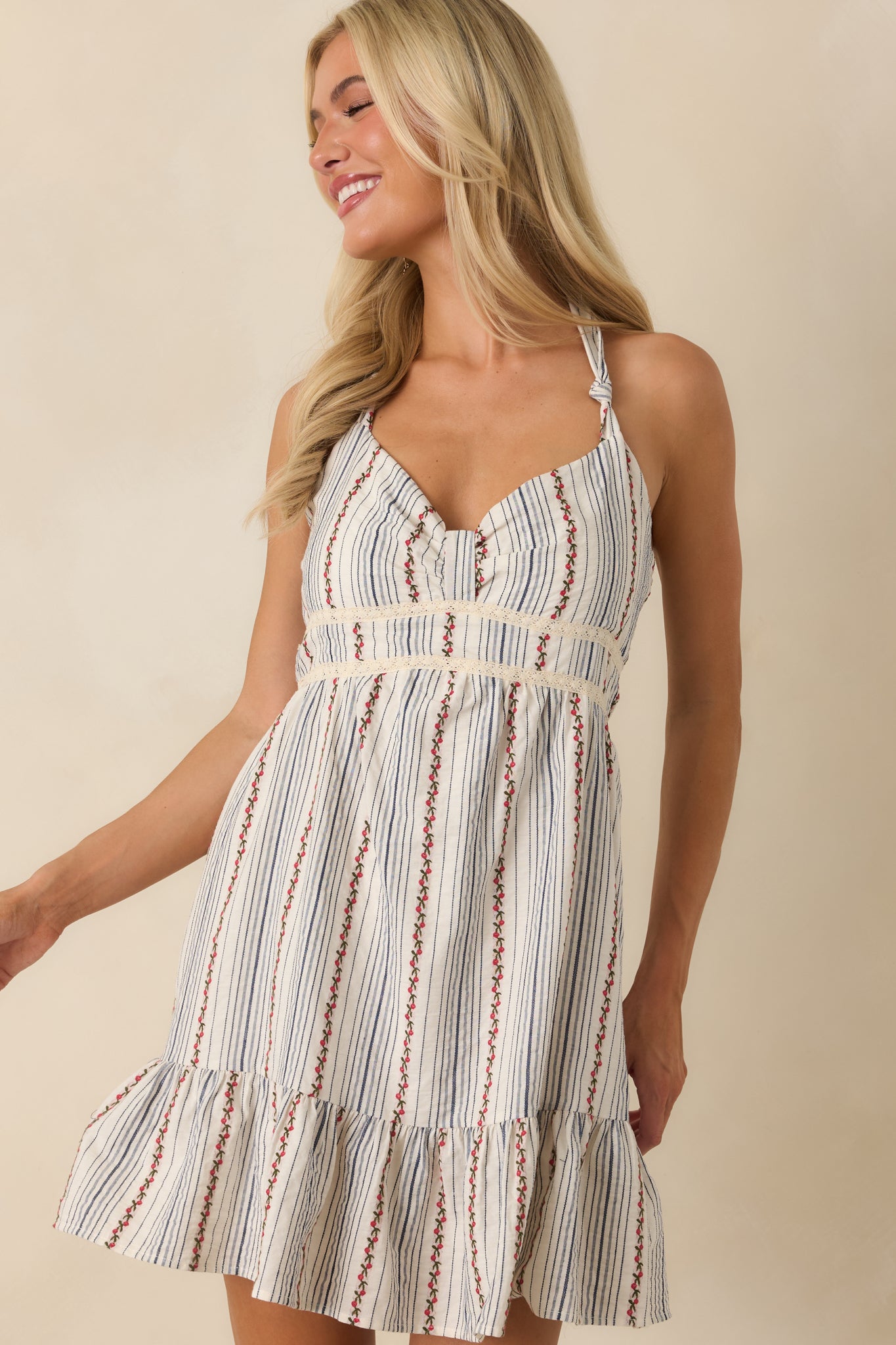 Close-up of the mini dress showcasing the ruffled hem, fit-and-flare shape, and embroidered floral detailing.