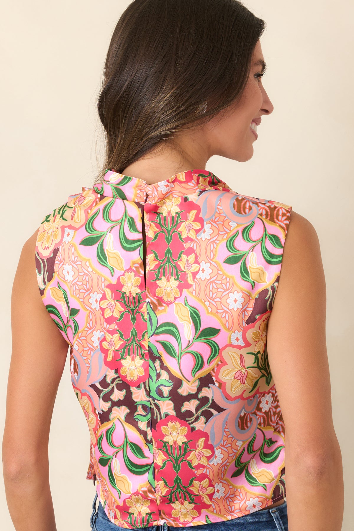 Rear of the sleeveless floral satin top showing the colorful print and smooth silhouette.