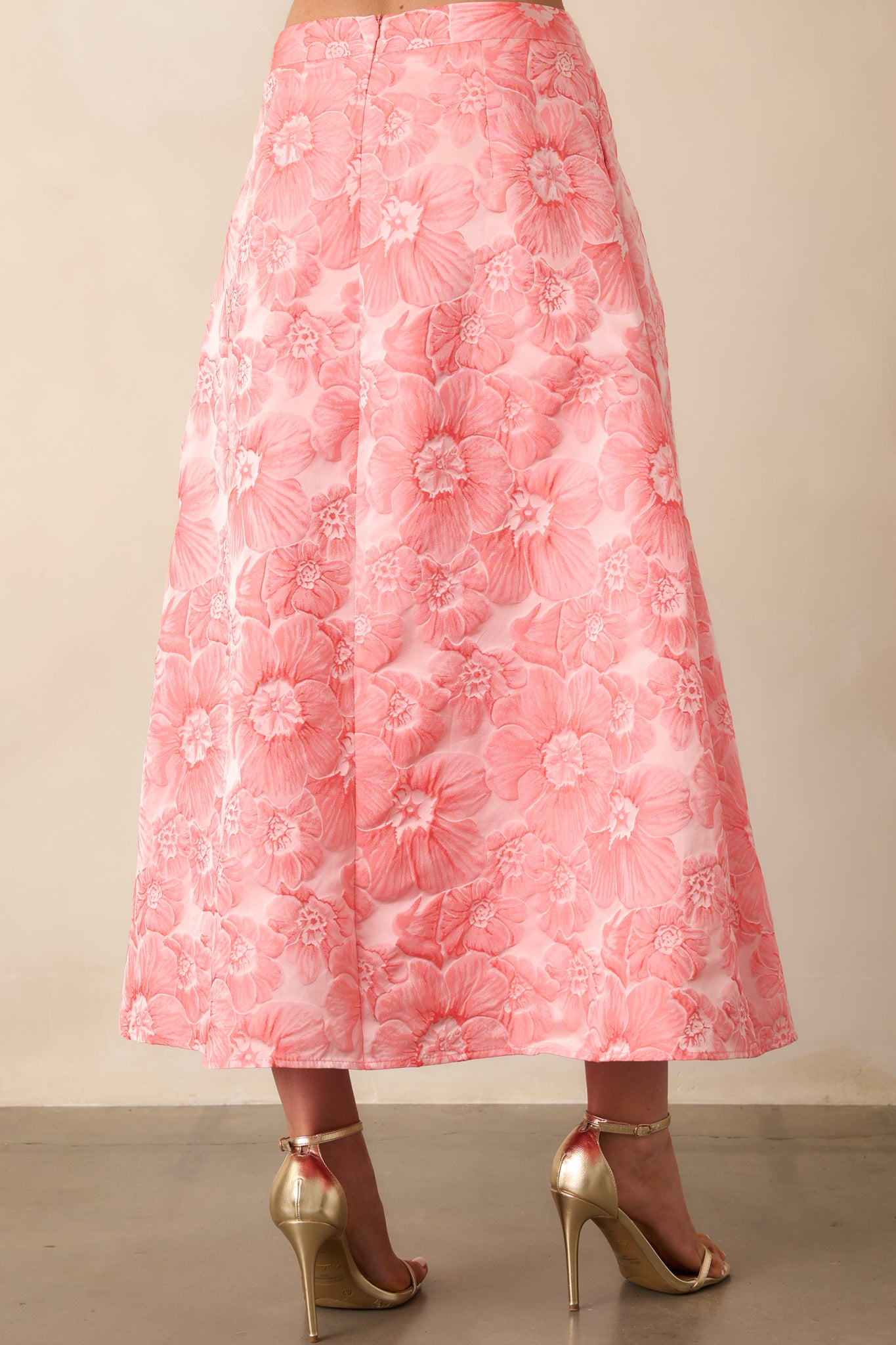 A view from behind showing the discrete zipper and smooth finish of the high waisted floral skirt.
