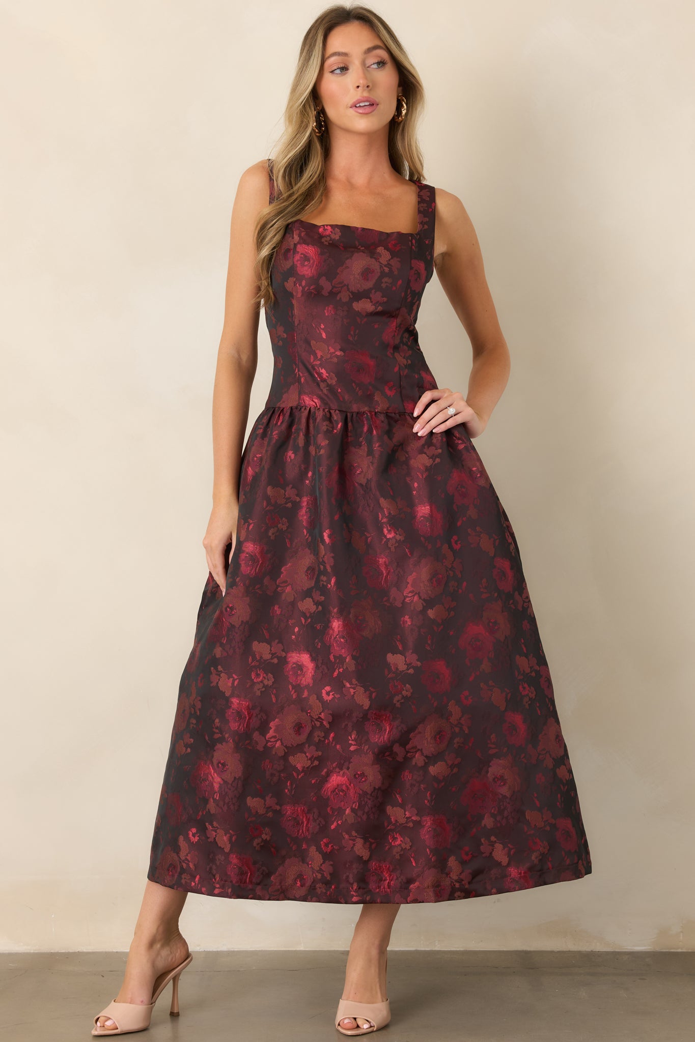 Statement floral dress featuring a sculpted sleeveless upper silhouette and softly gathered midi skirt with graceful fullness.