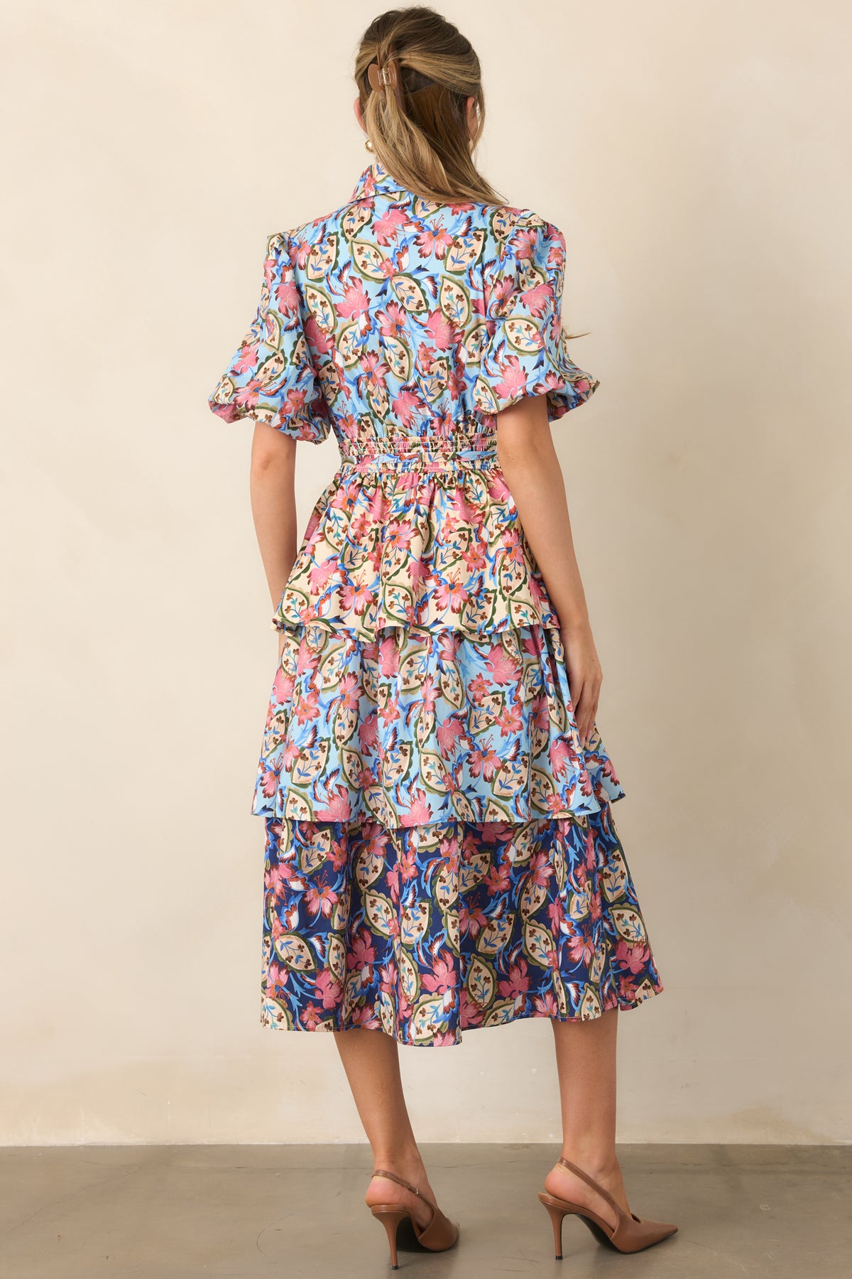 Rear of the floral dress featuring a smocked back waist and flowing layered skirt.
