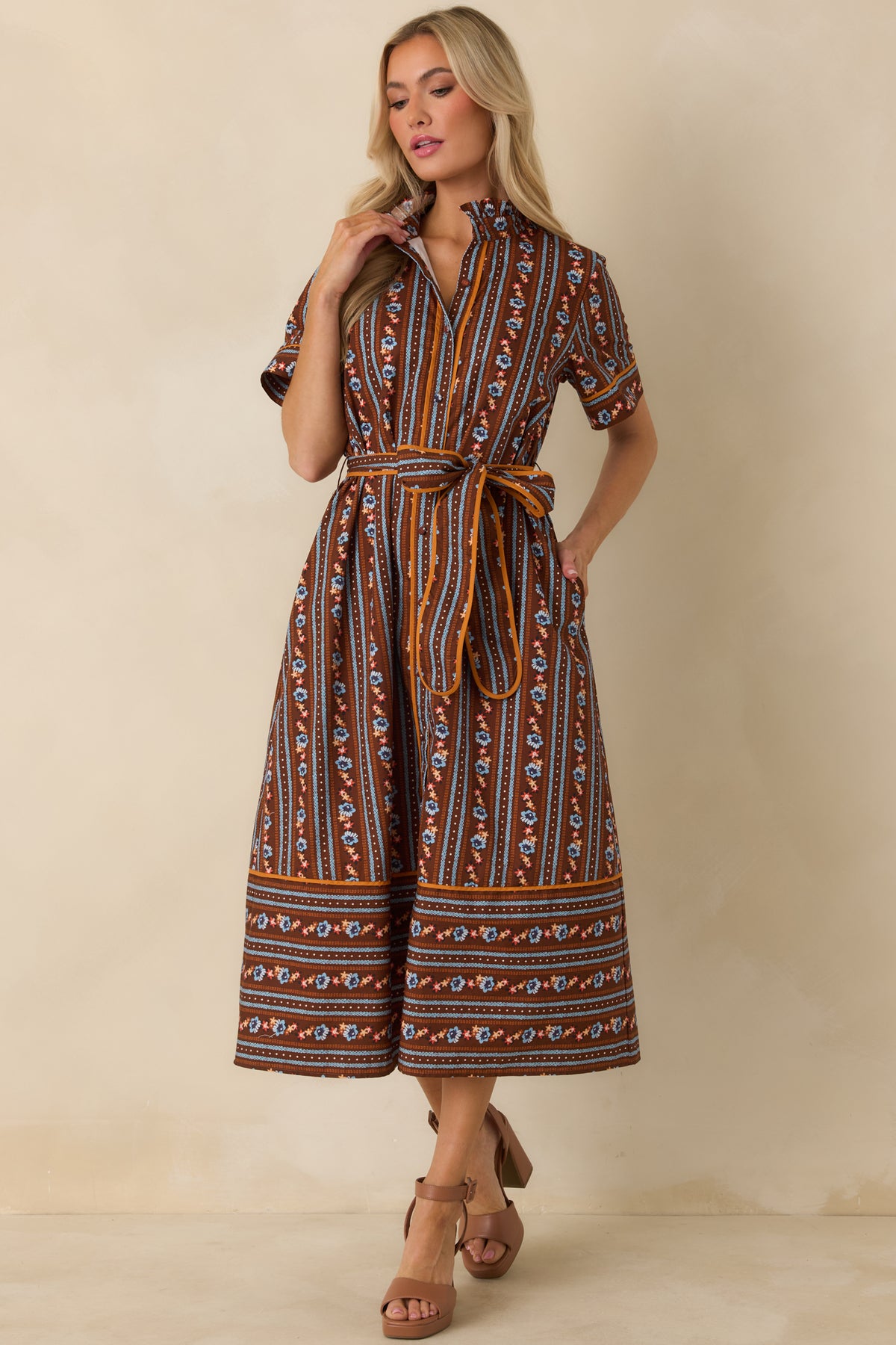 Floral and patterned stripe dress with a ruffled stand collar, button-front closure, removable tie belt, and convenient side pockets.
