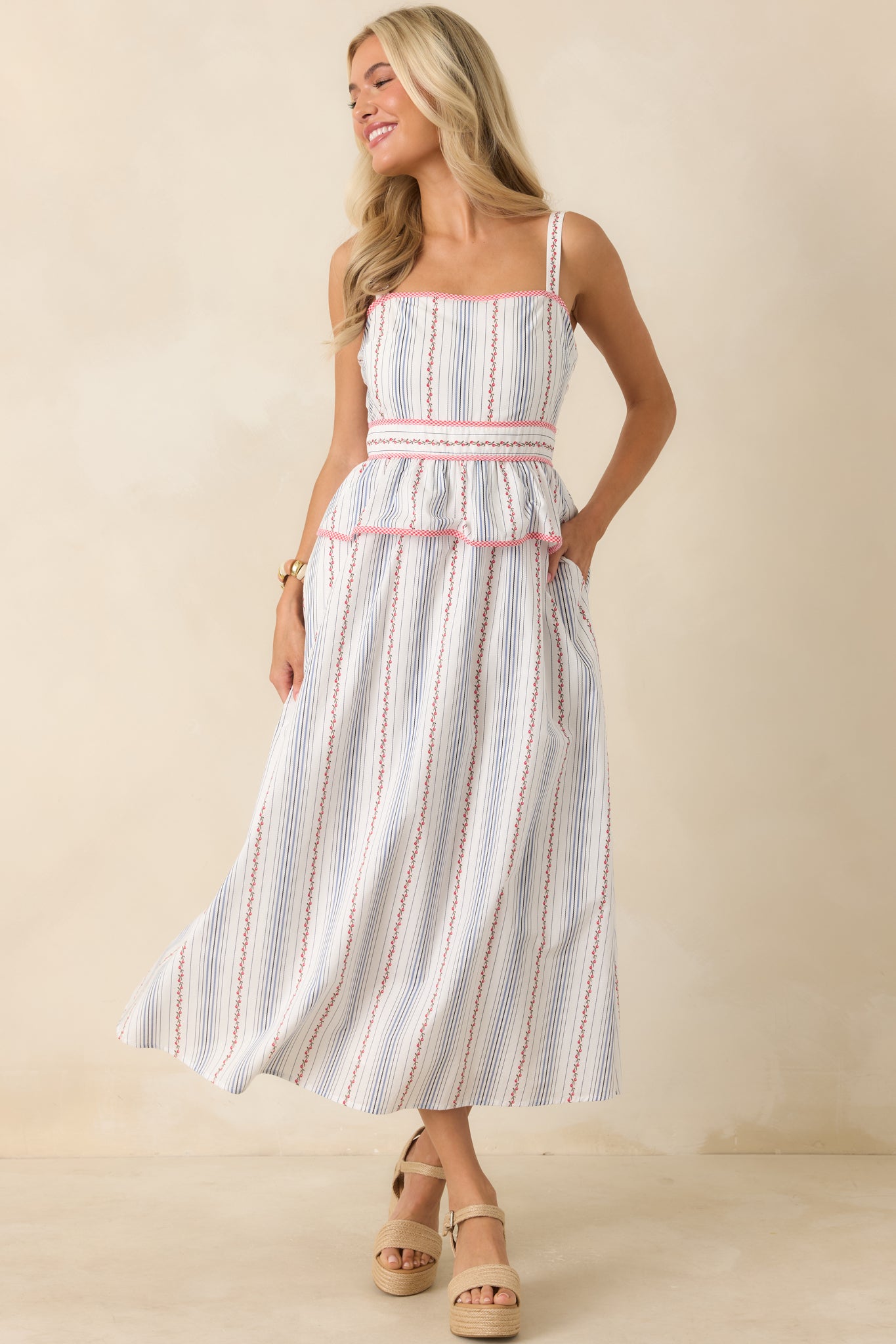 Floral stripe midi dress featuring a square neckline, adjustable shoulder straps, red gingham trim, peplum waist, and flowing full skirt.