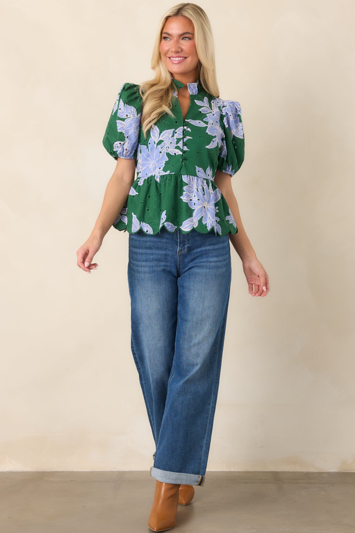 Soft floral top showcasing textured eyelet accents, voluminous puff sleeves, a functional button-front design, and feminine scalloped edging.