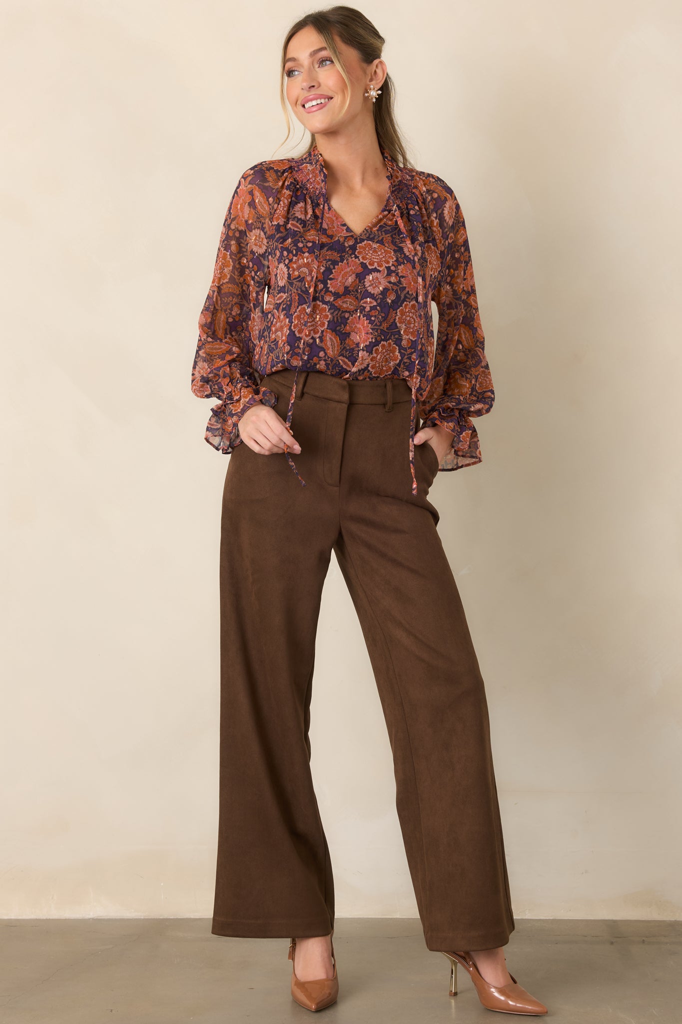Floral top with a softly ruffled split neckline, long sheer sleeves, and lightweight flowing silhouette.