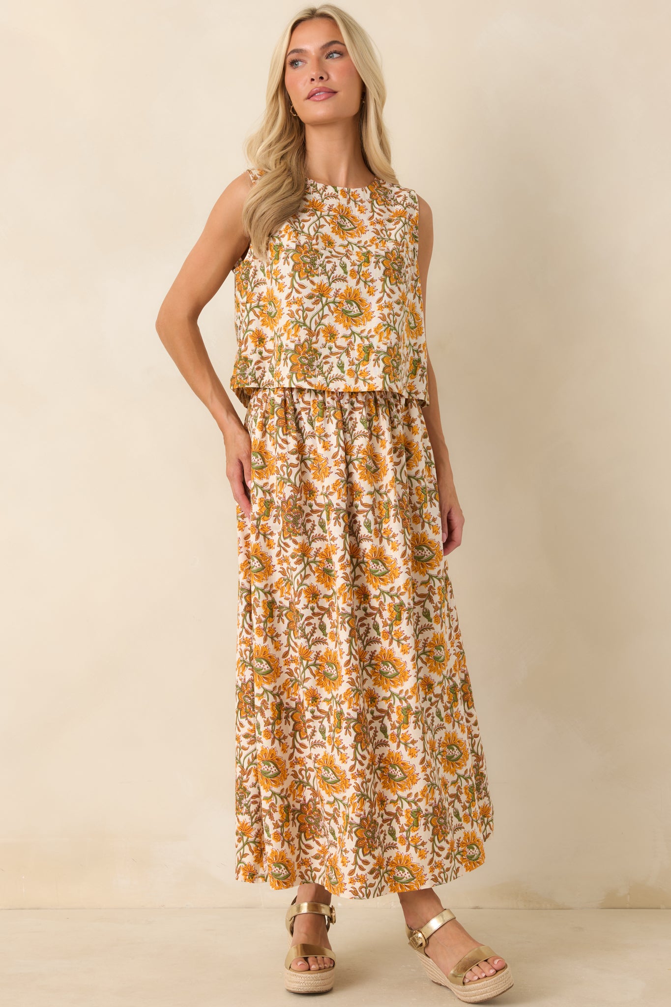 Flowing floral maxi skirt featuring an elastic waistband, functional side pockets, and a warm marigold and olive print.