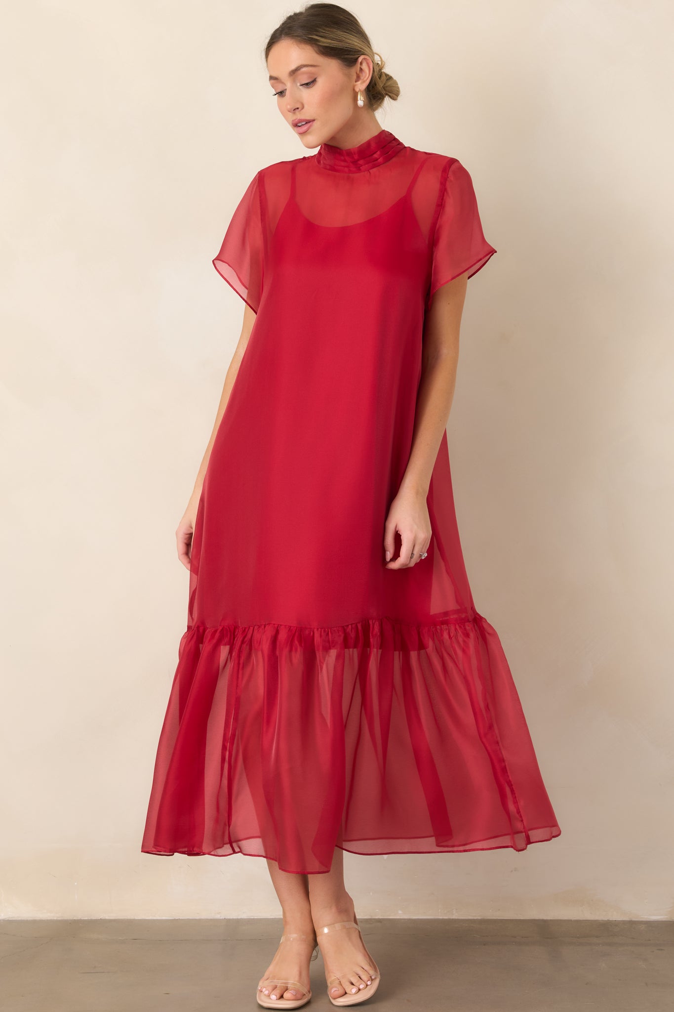 Flowing organza maxi dress featuring a lightweight sheer layer over a coordinating slip, polished mock neckline, and gathered ruffle hem.