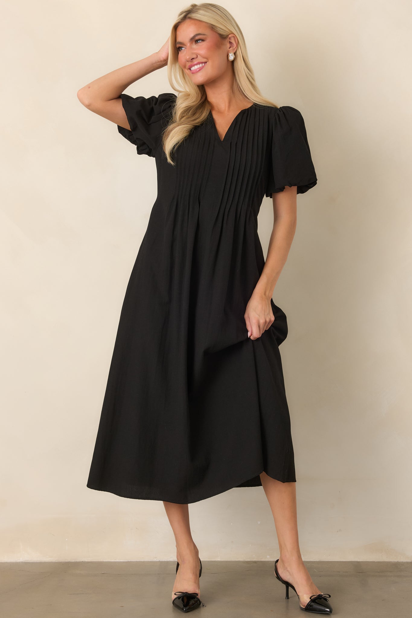 Flowing rayon-nylon midi dress showcasing softly gathered puff sleeves, a V-neckline, and vertical pintuck accents that add subtle structure.
