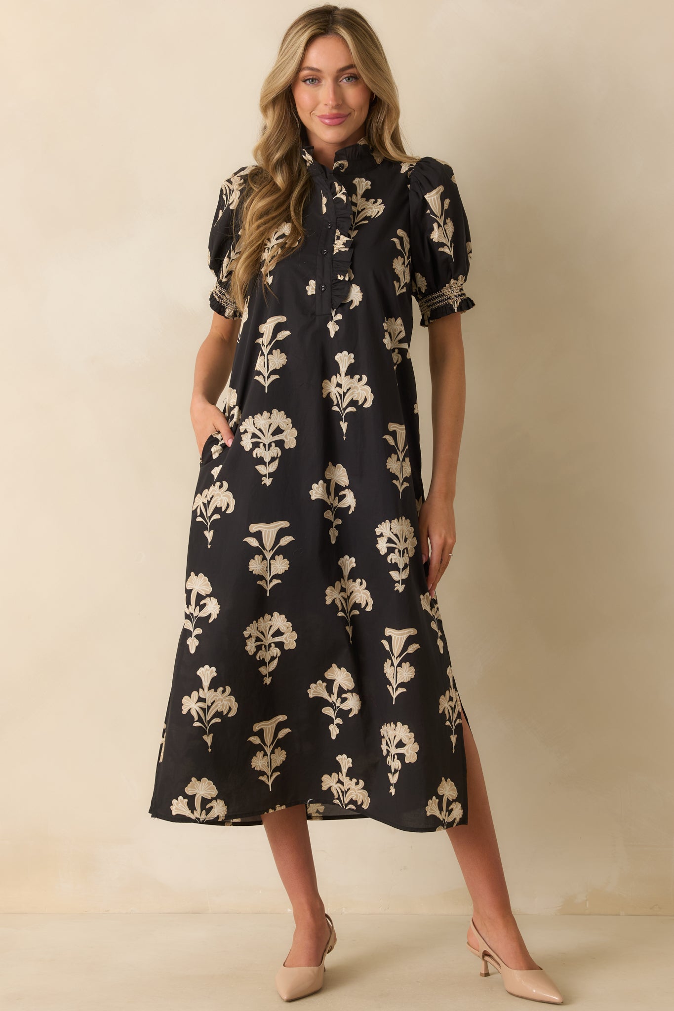 Flowy black floral dress featuring a quarter button front placket with ruffle trim and subtle side slits at the hem.