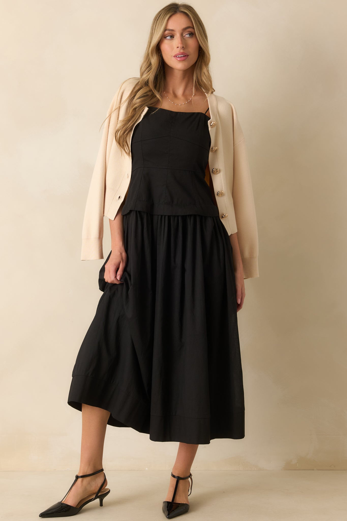 Flowy black midi dress featuring a structured bodice, full lining, and a relaxed silhouette.