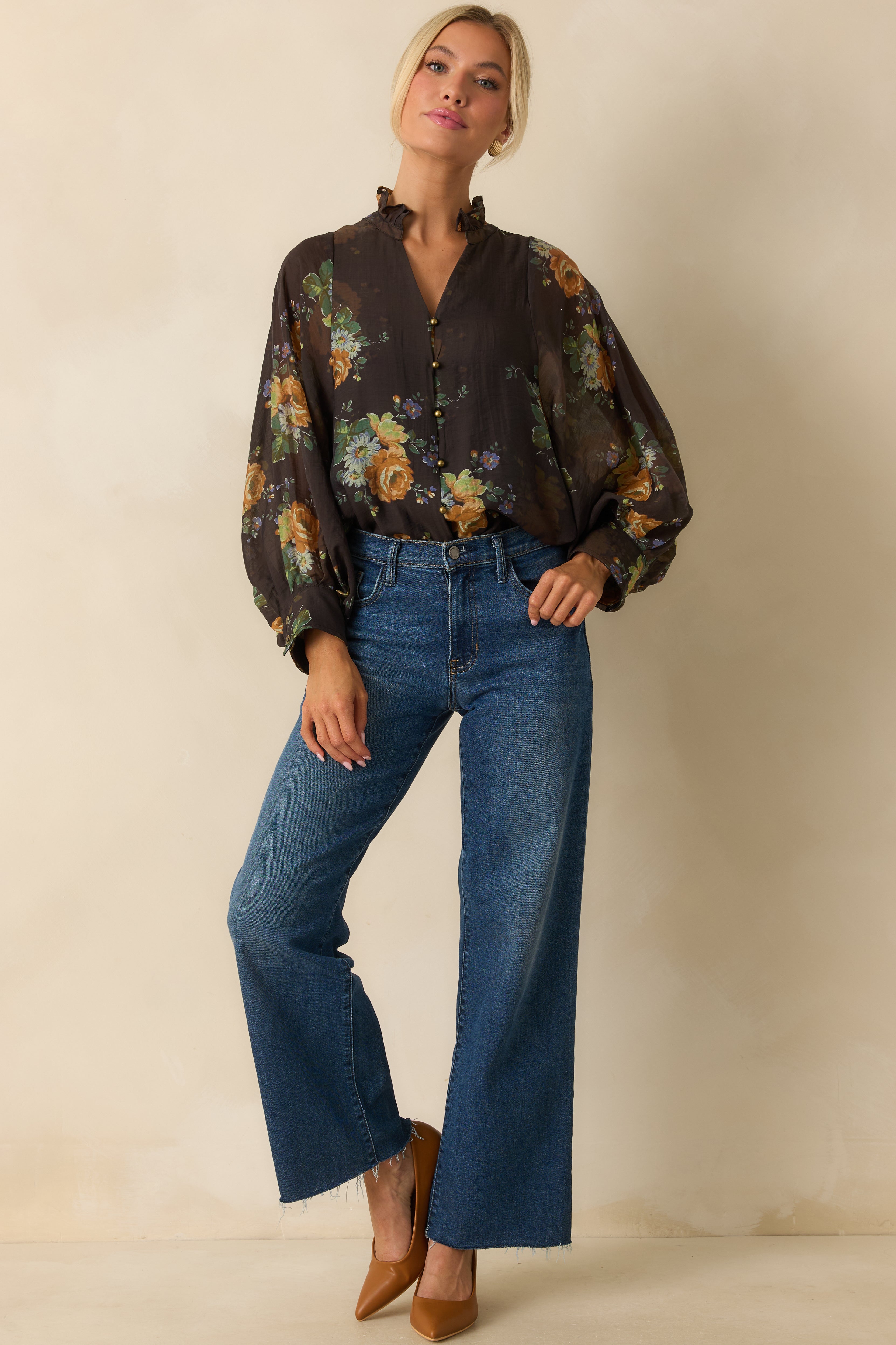 Flowy brown blouse with long sleeves, gold buttons, and vibrant floral pattern.