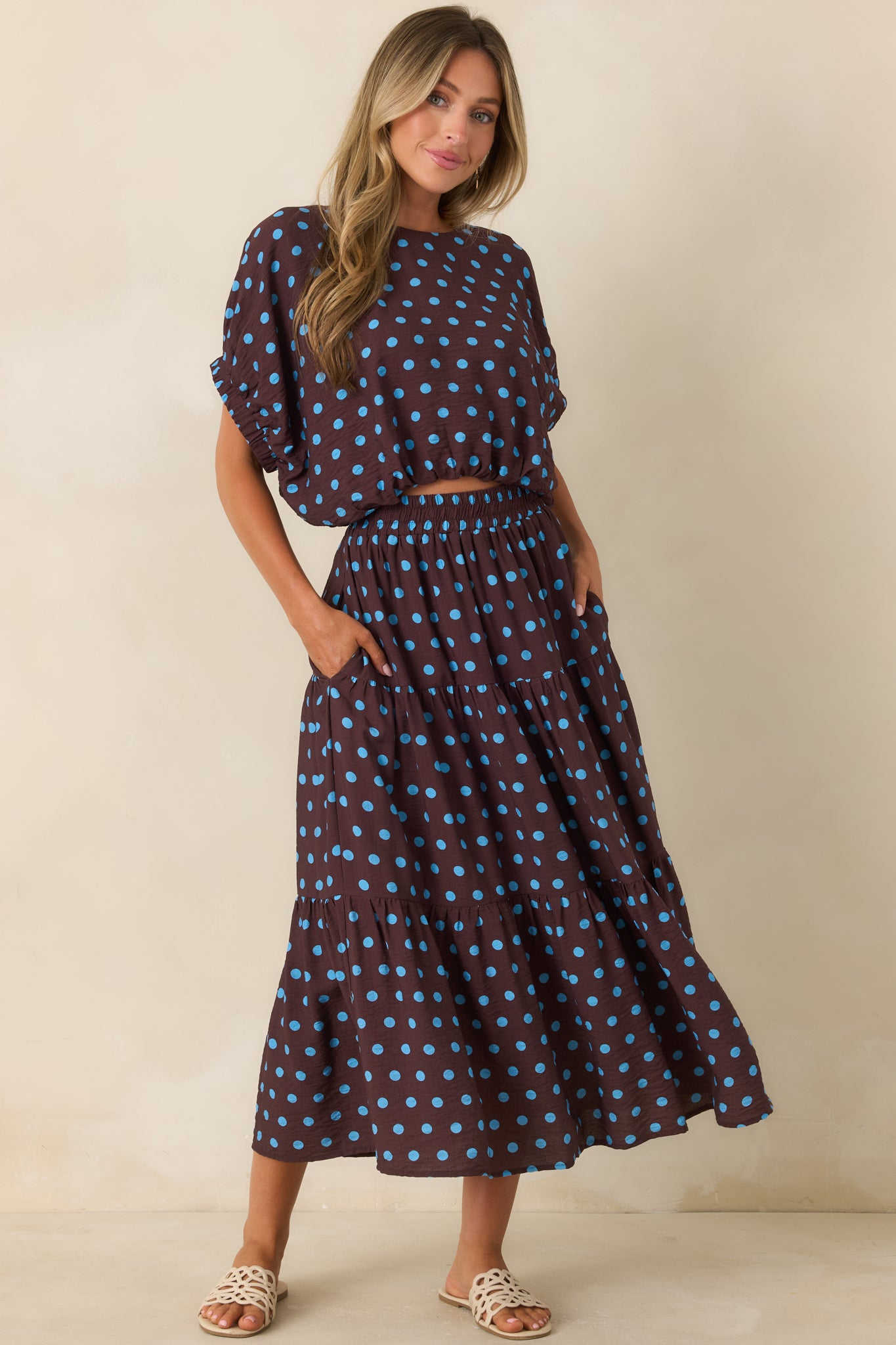 Flowy brown midi skirt showcasing a comfortable smocked waistband, vibrant polka dots, and soft gathered volume.