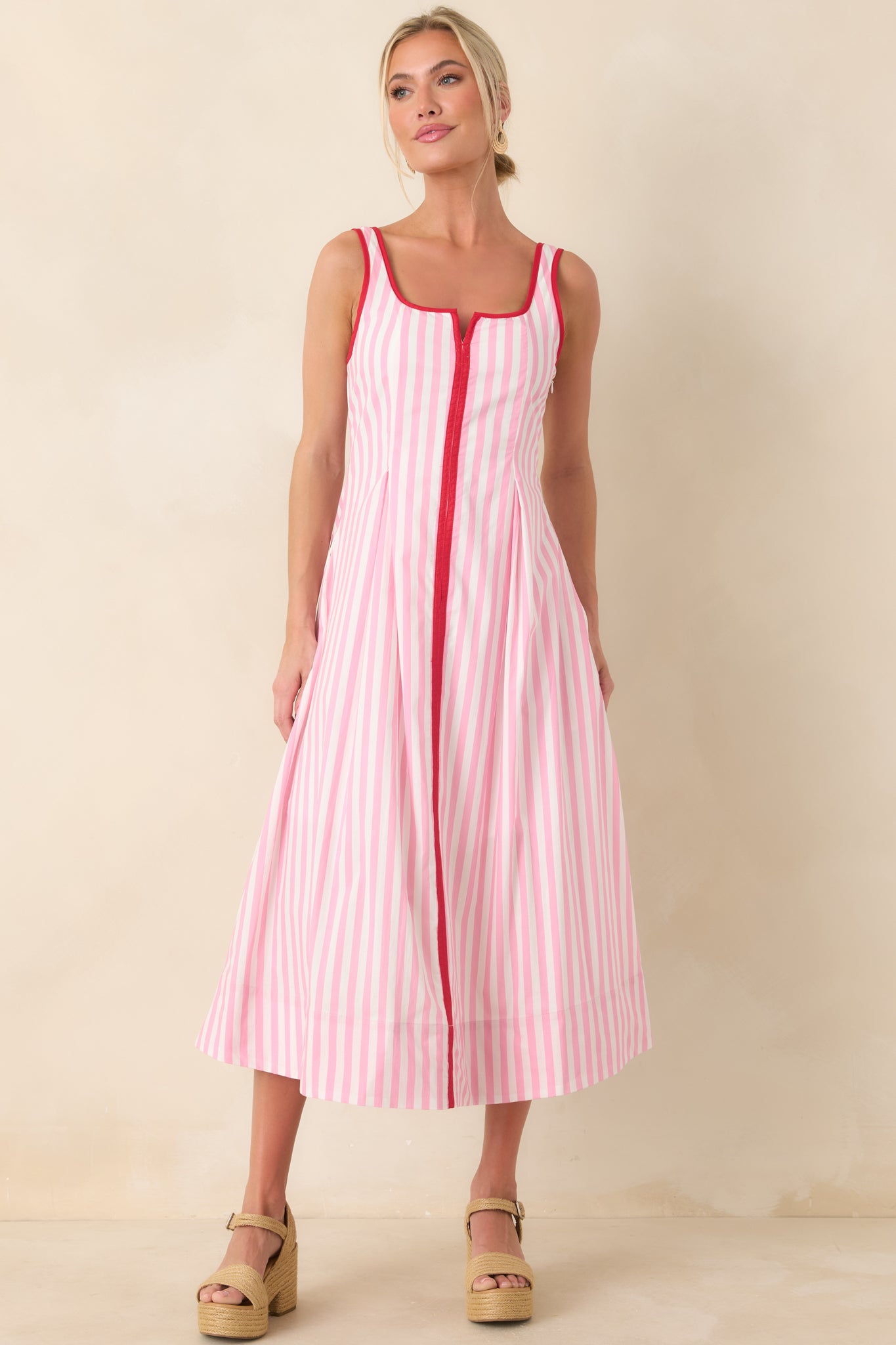 Flowy midi dress with fitted waist, subtle red trim details, and lightweight fabric.