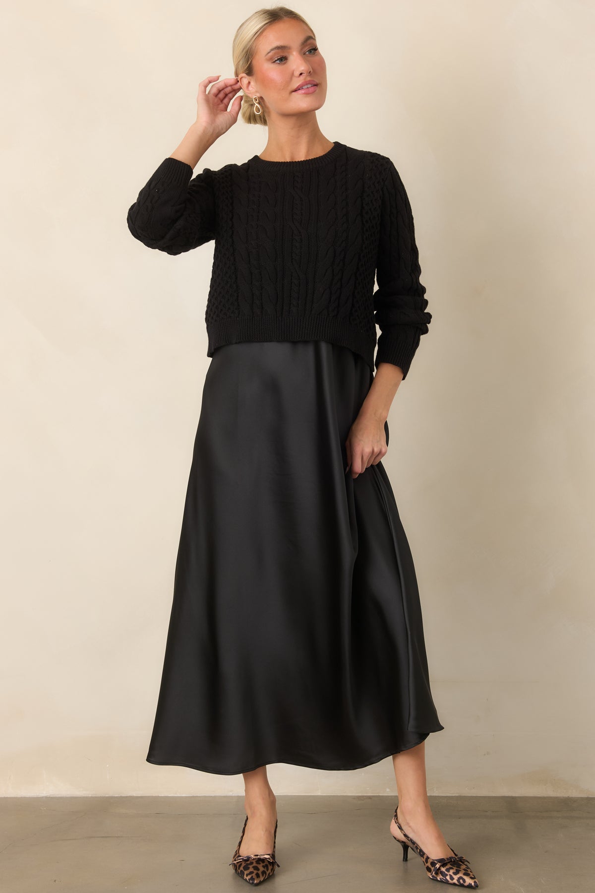A fluid satin maxi dress pairs with a cropped sweater featuring intricate mixed cable-knit texture.