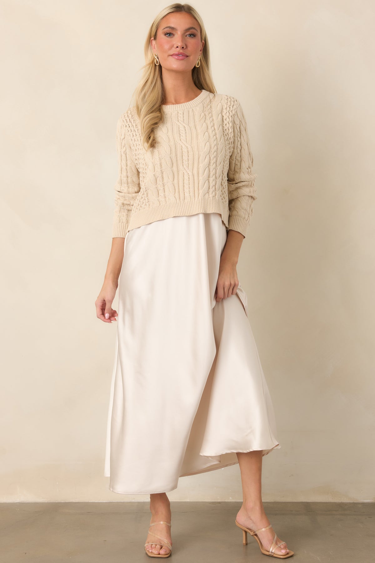 Fluid maxi dress with a softly gathered drape and cropped textured sweater creating a layered silhouette.