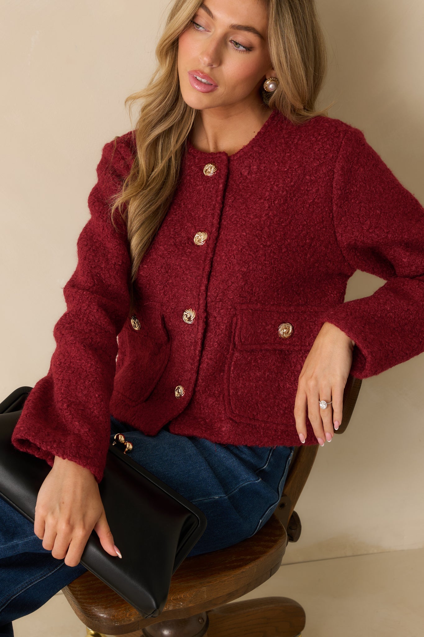 Front-focused detail showing the long sleeves and polished gold buttons.