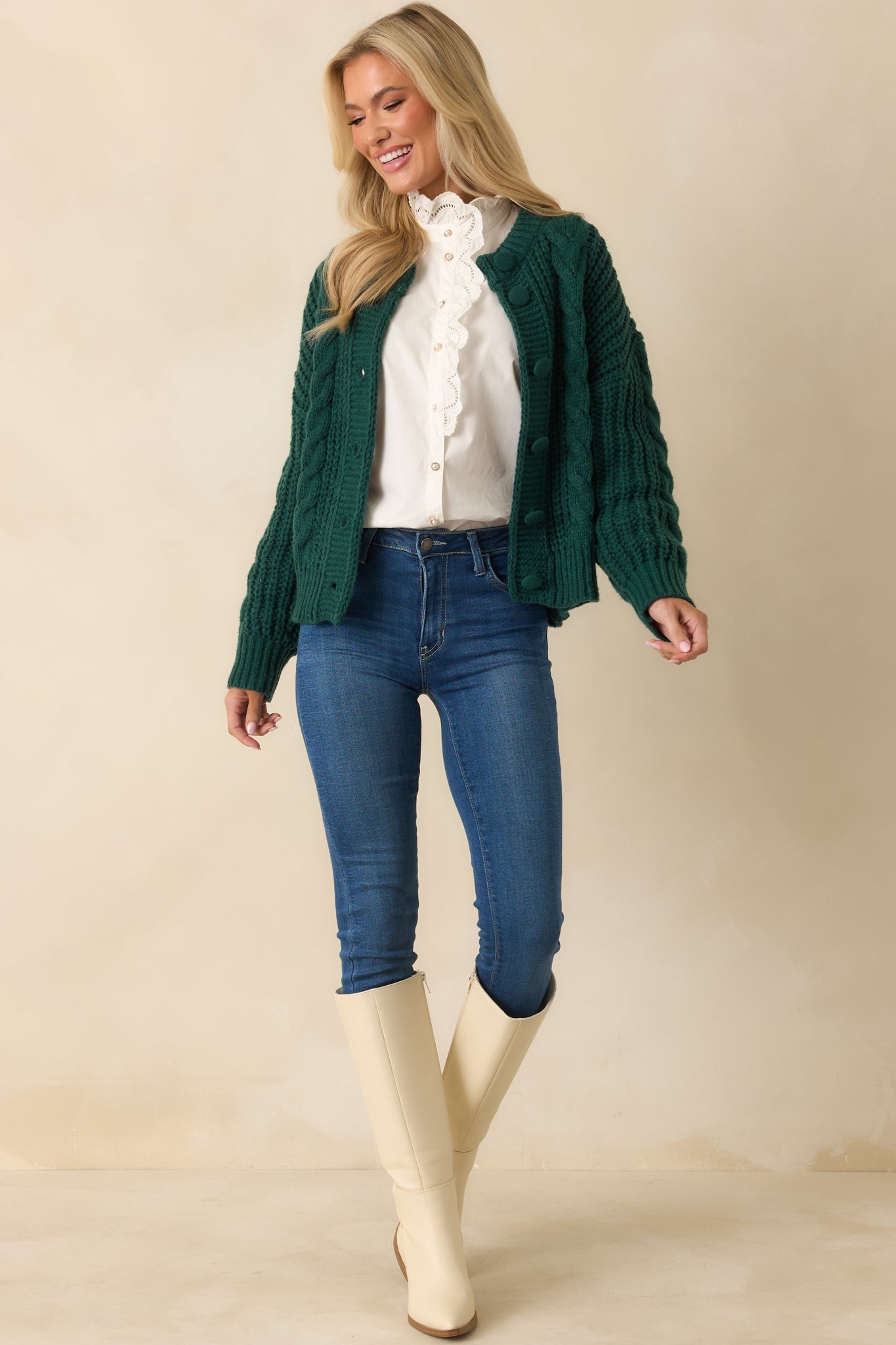 Full-length front view of forest green cardigan showing chunky cable knit, crew neckline, and relaxed fit.