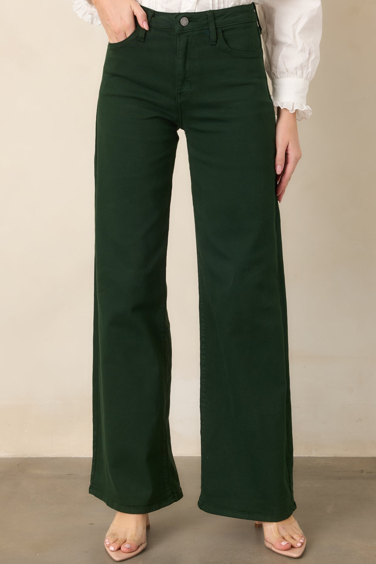 Close view of the forest green denim highlighting the smooth high-rise waistband and softly textured cotton-blend fabric.