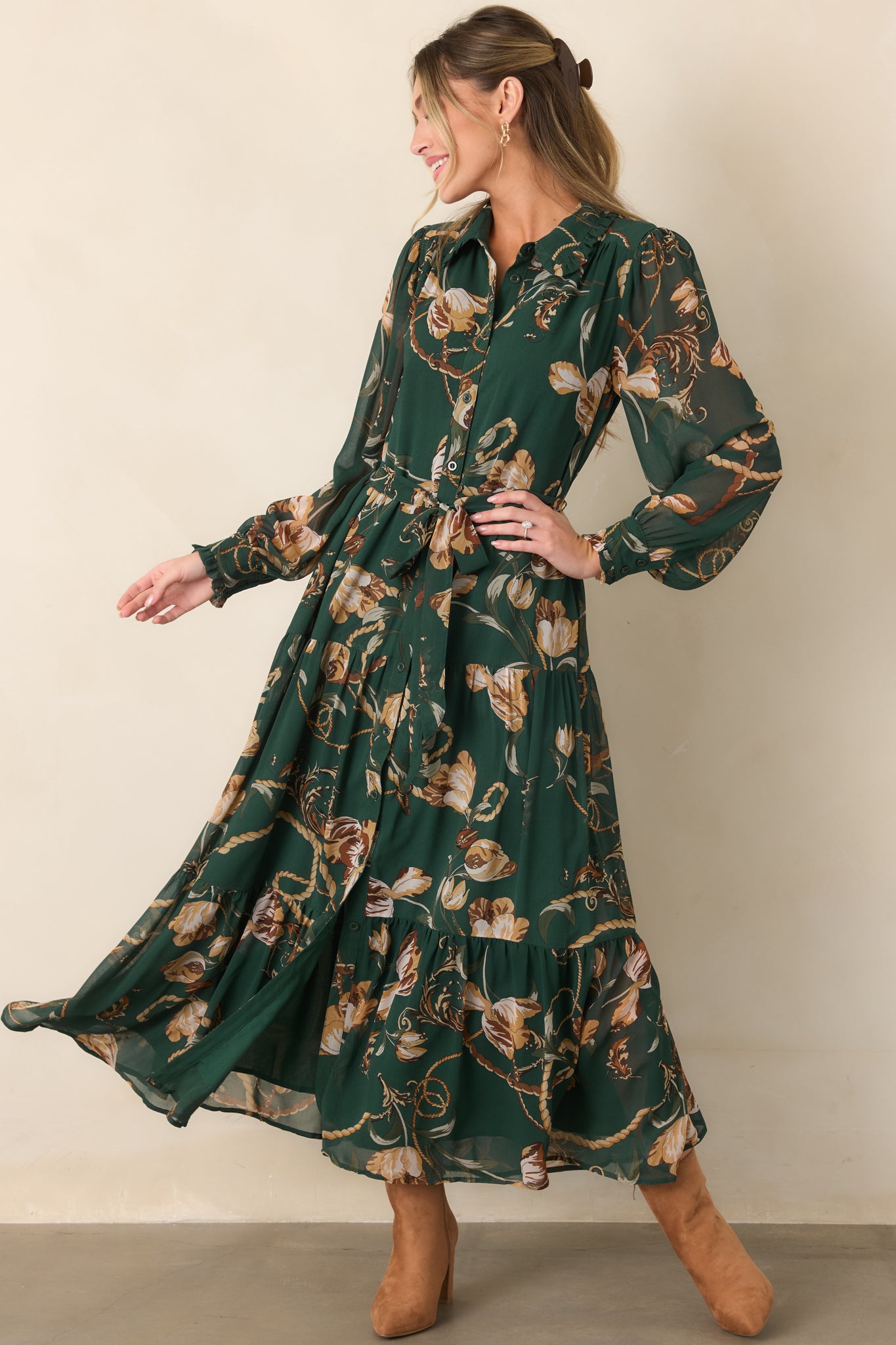 Forest green printed shirt dress highlighting its warm camel and cream accents, adjustable waist tie, flowing tiered skirt, and sheer sleeves.