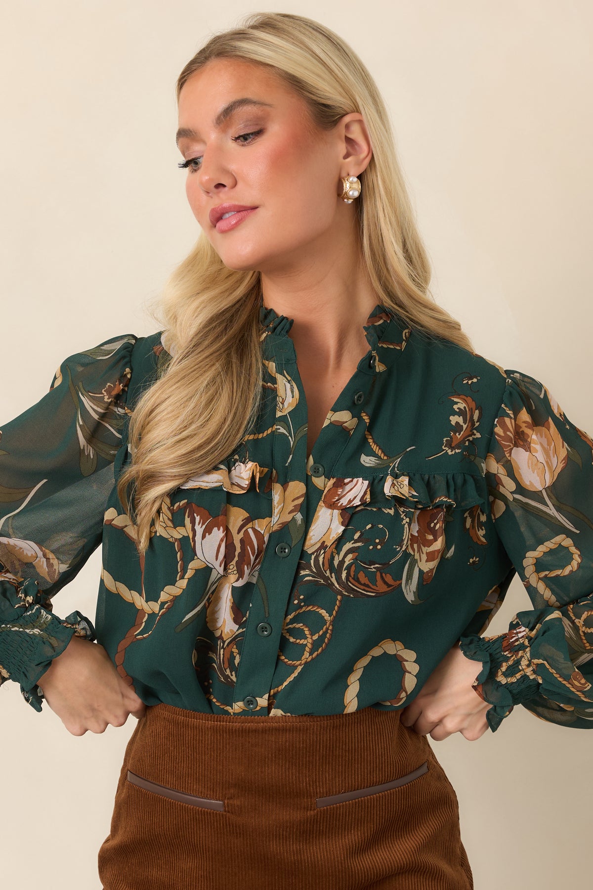 Sheer-sleeved forest green top finished with a ruffled neckline and coordinating smocked cuffs.