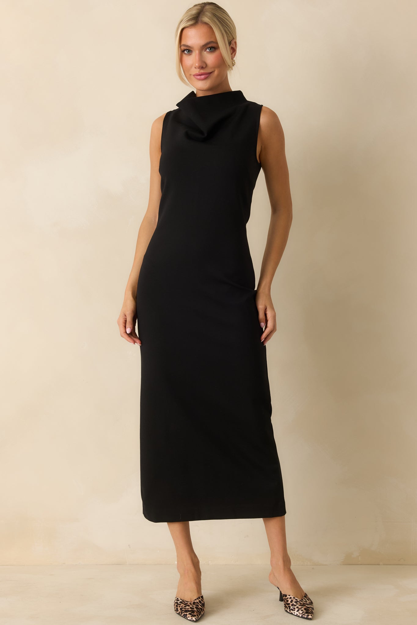 Form-fitting black sleeveless dress with a bodycon cut and high neckline, designed to shape and contour the figure.