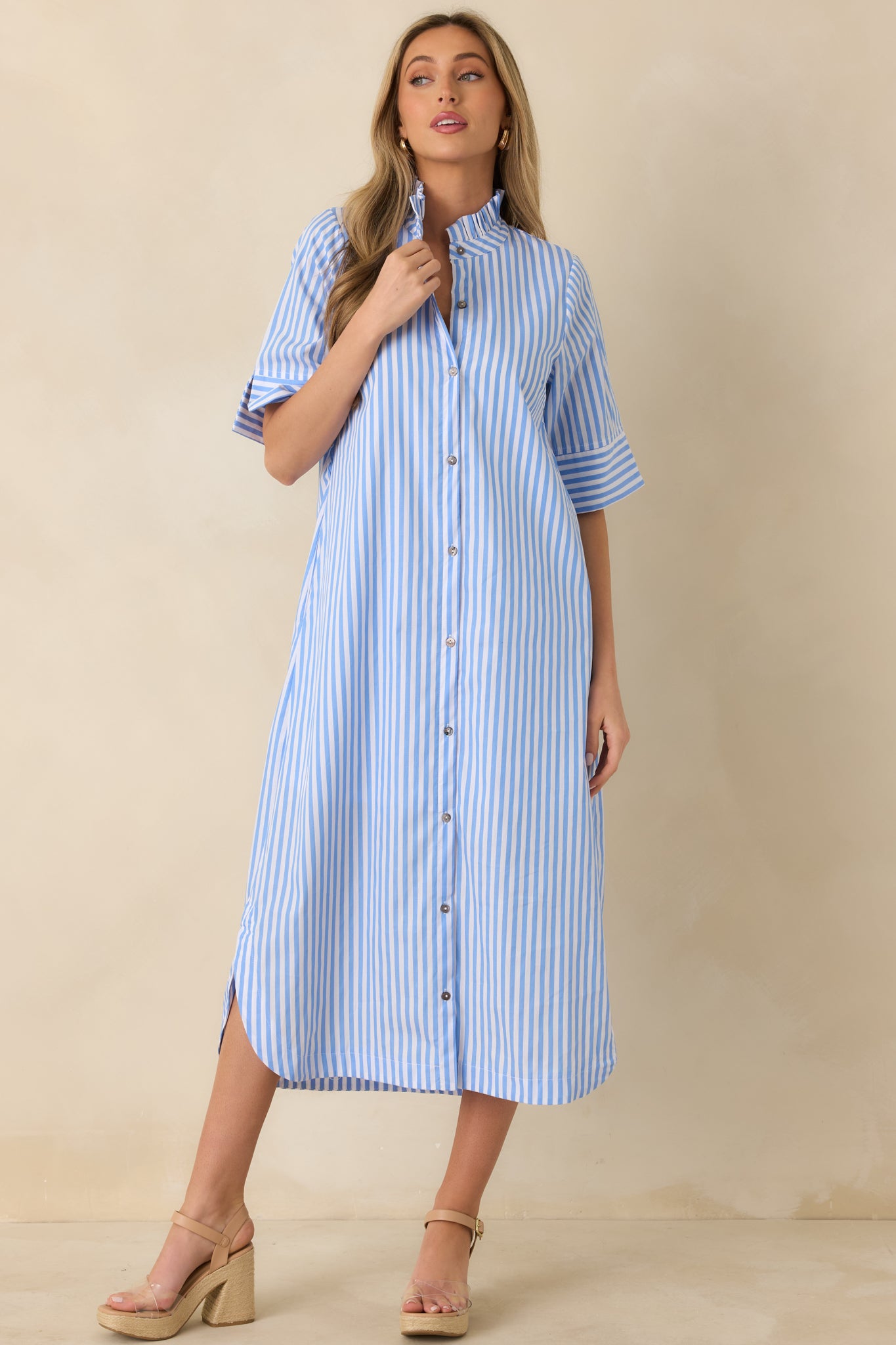 Front-facing angle of blue striped shirt dress with soft ruffle collar and fluid skirt movement.