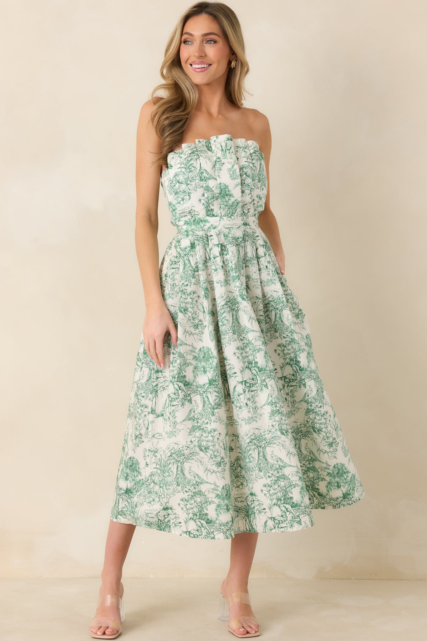Front-facing angle of green strapless midi dress highlighting the structured pleats on the bodice and flowing skirt.
