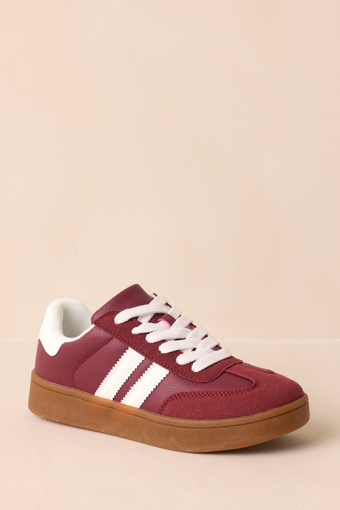 Three-quarter front angle showing the rounded toe, suede texture, and white side stripe detailing.