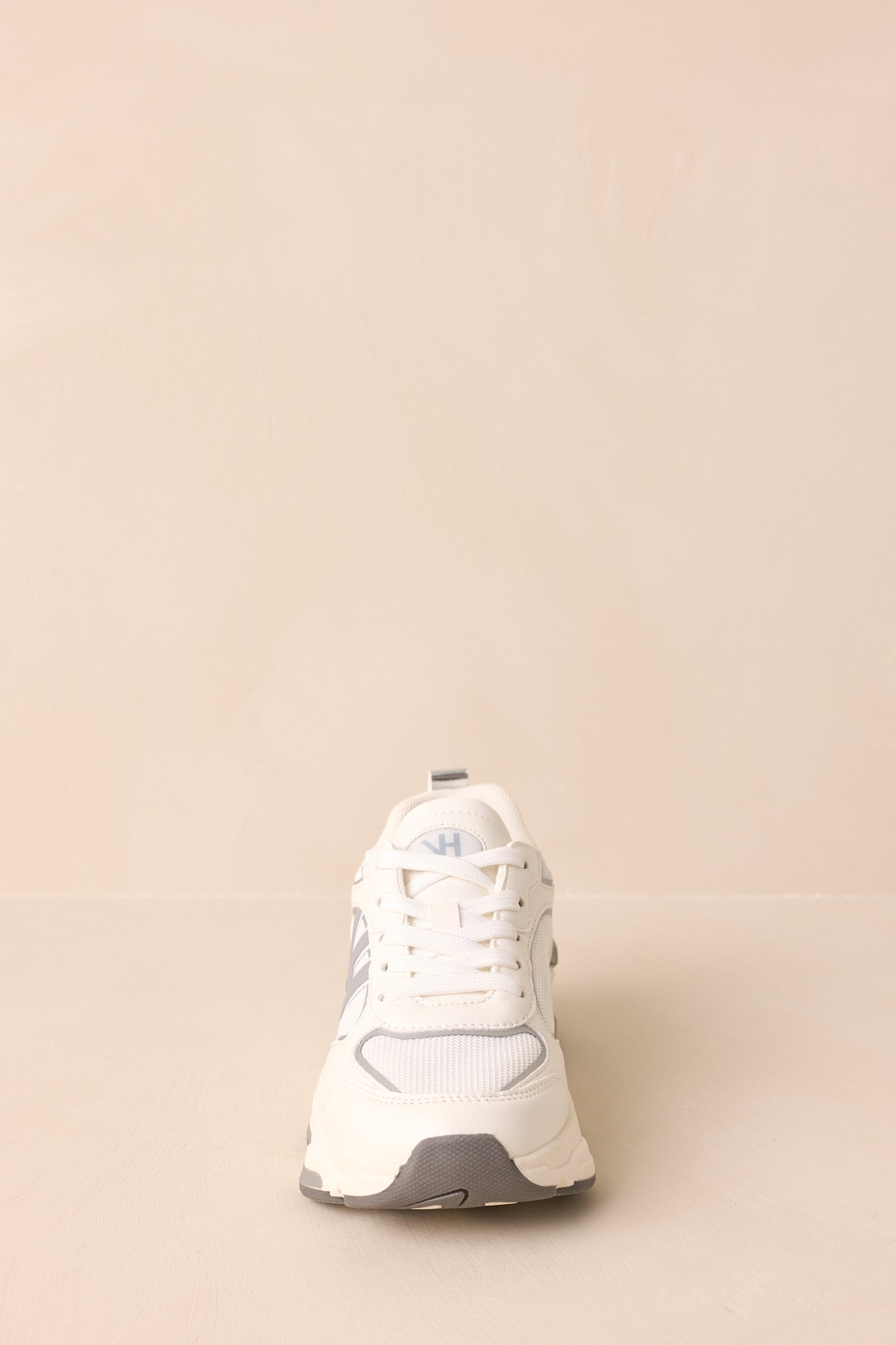 Front angle showing rounded toe, cushioned sole, and smooth white base with subtle grey detailing.