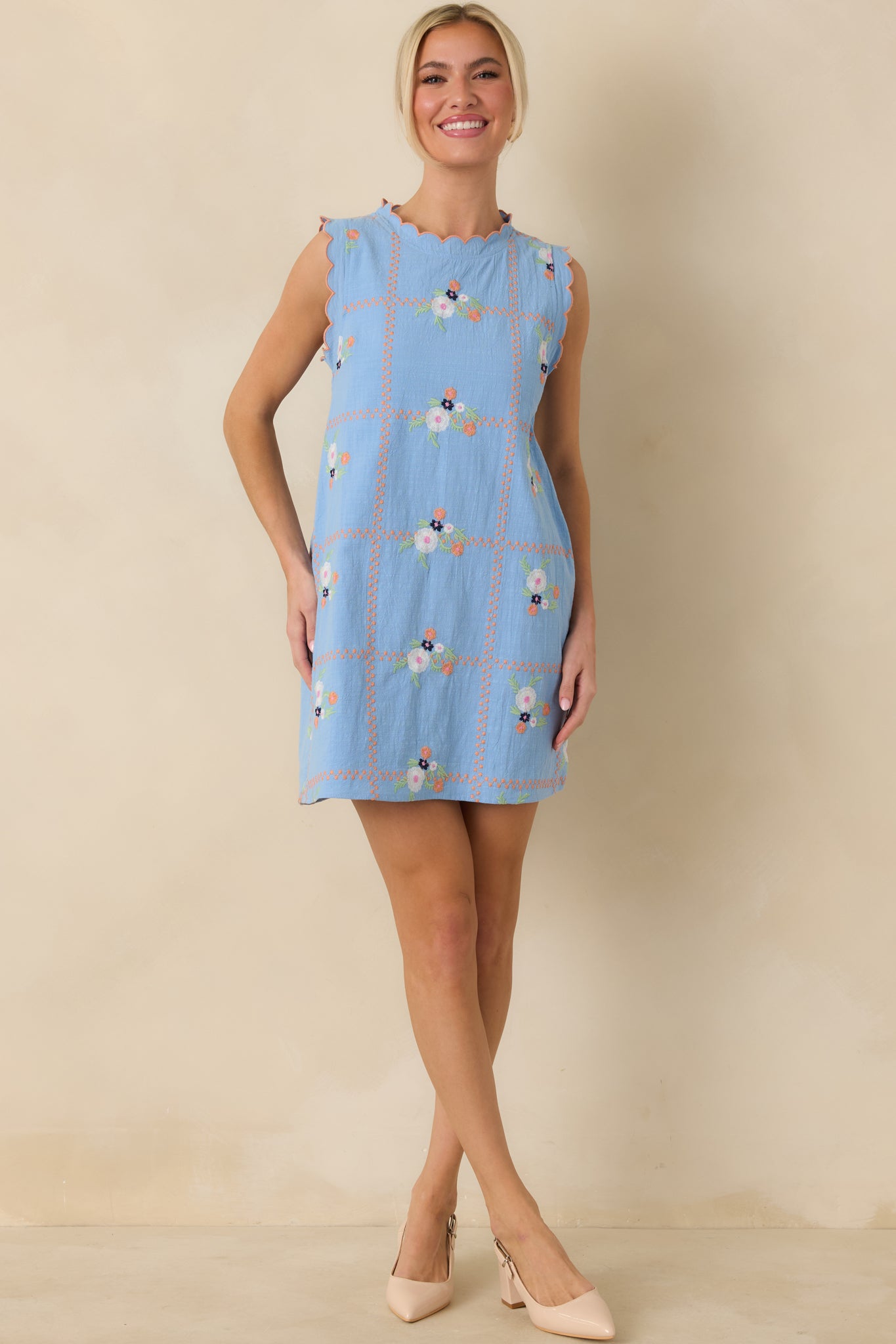 Straight-on front angle showing the smooth drape, sleeveless cut, and subtle embroidered pattern of the light blue dress.