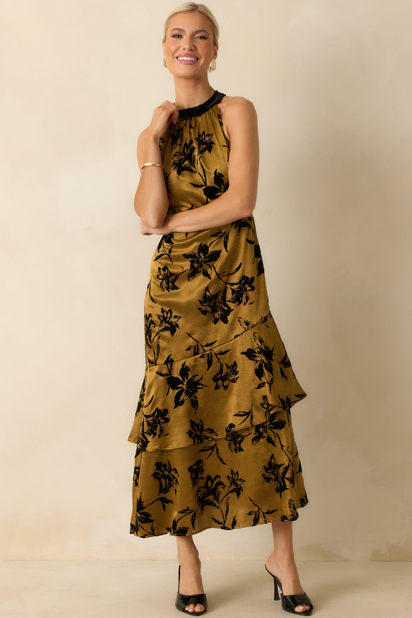 Front angled shot capturing the tiered skirt movement and sheen of the gold floral satin fabric.