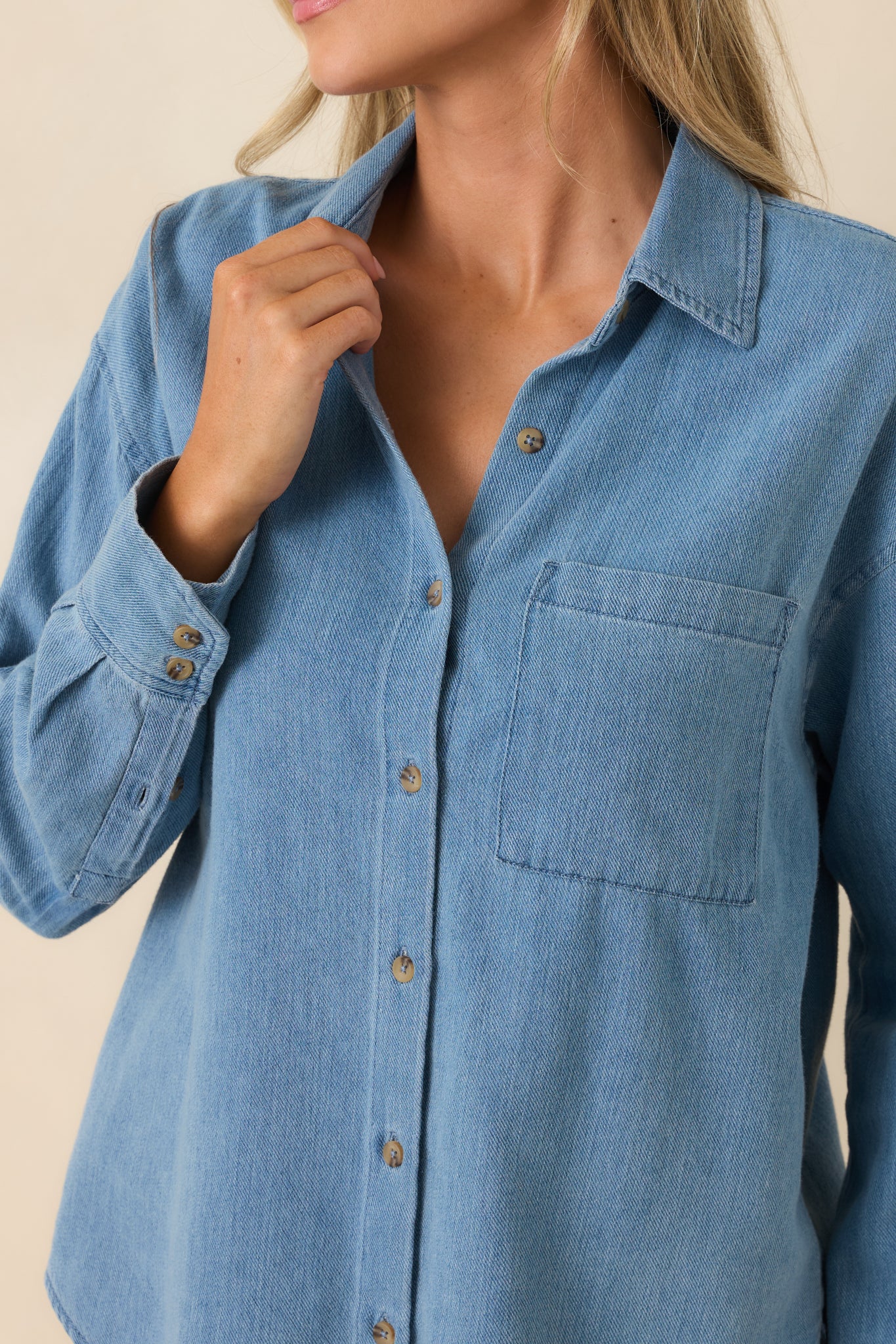 Close-up detail of the front buttons, collared neckline, and chest pocket on the relaxed fit top.