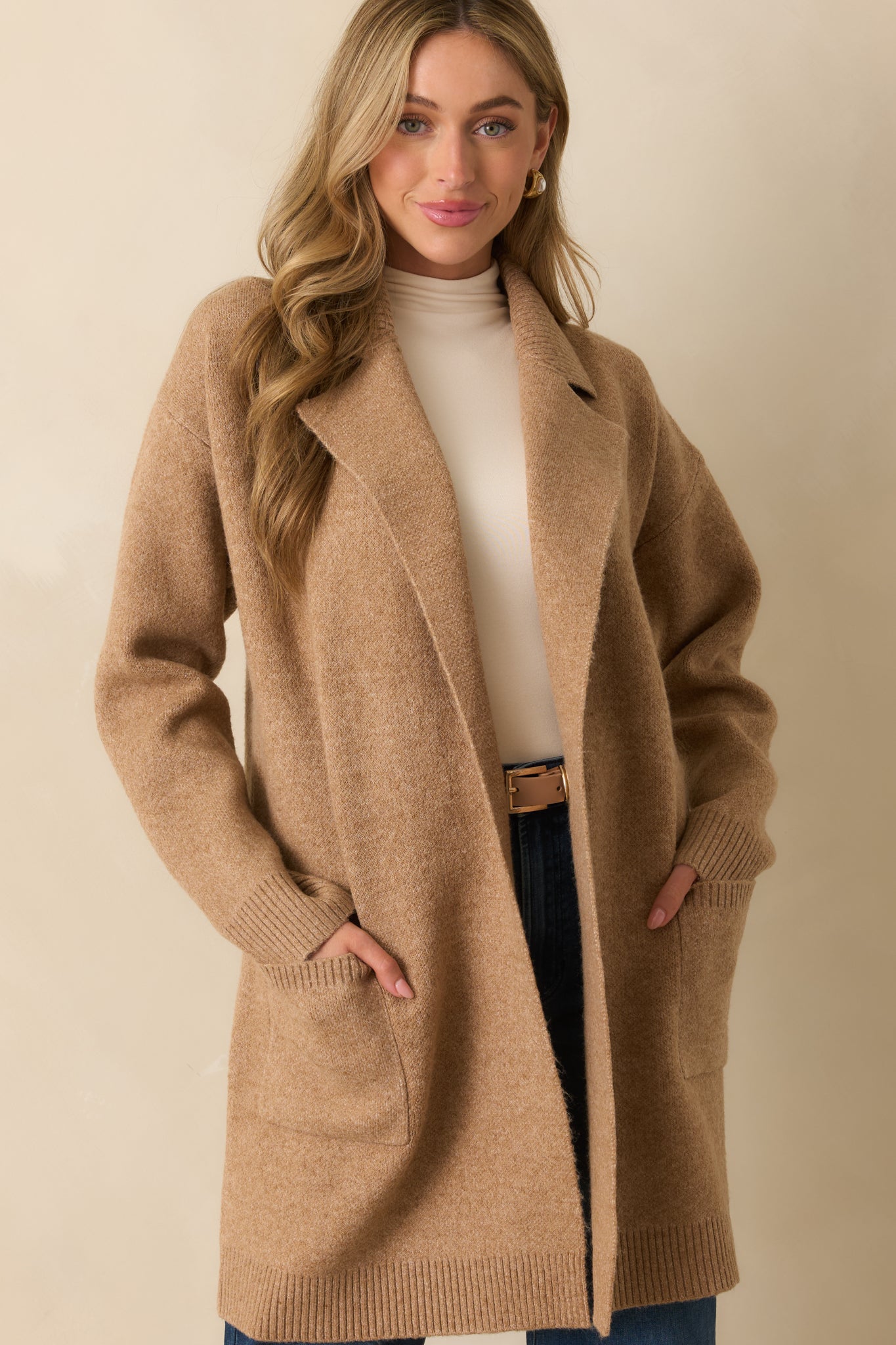 Front crop emphasizing drop shoulders and long sleeves with ribbed cuffs.