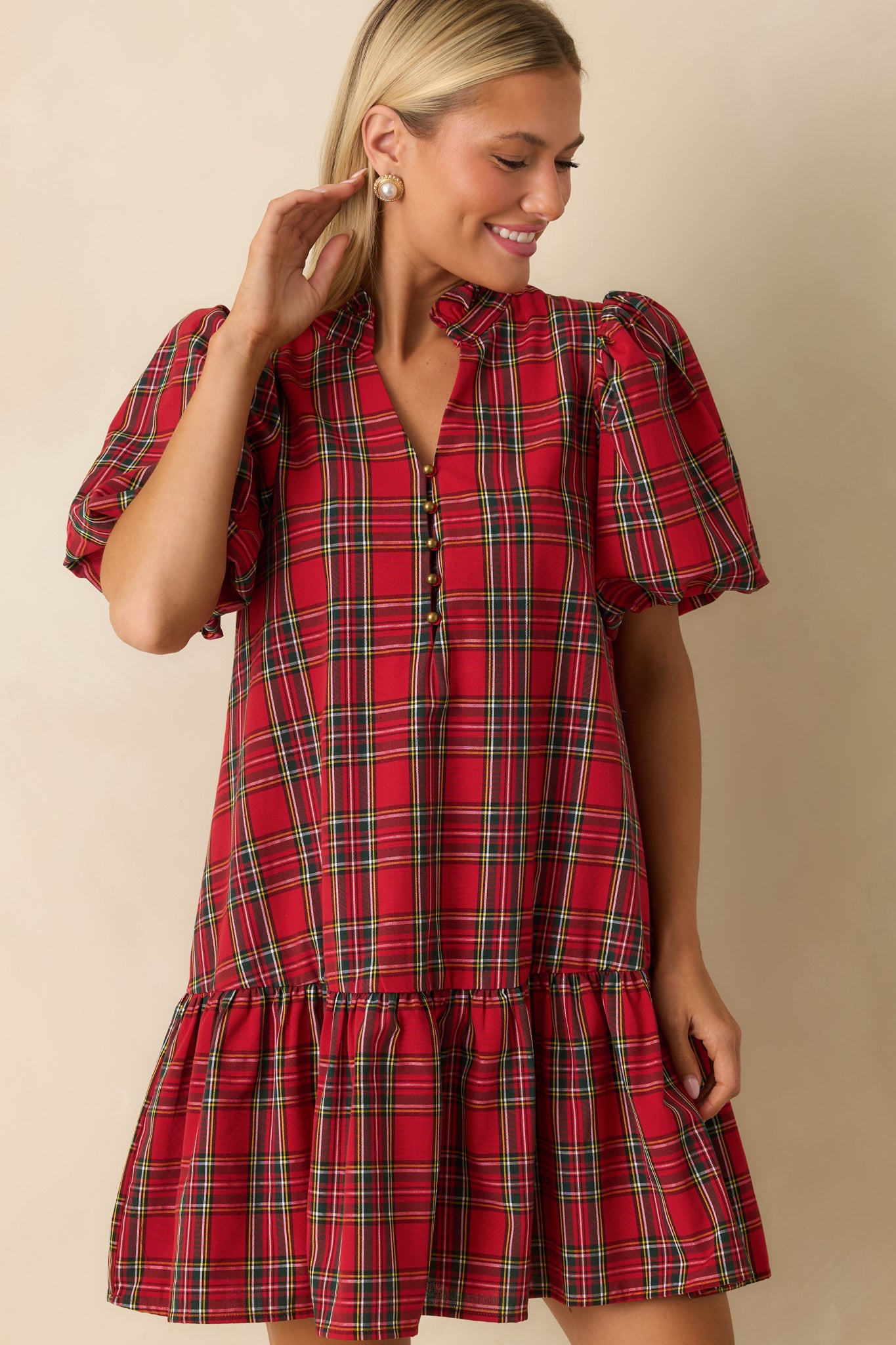 Front-focused crop highlighting ruffled drop hem and side pocket on the red plaid dress.