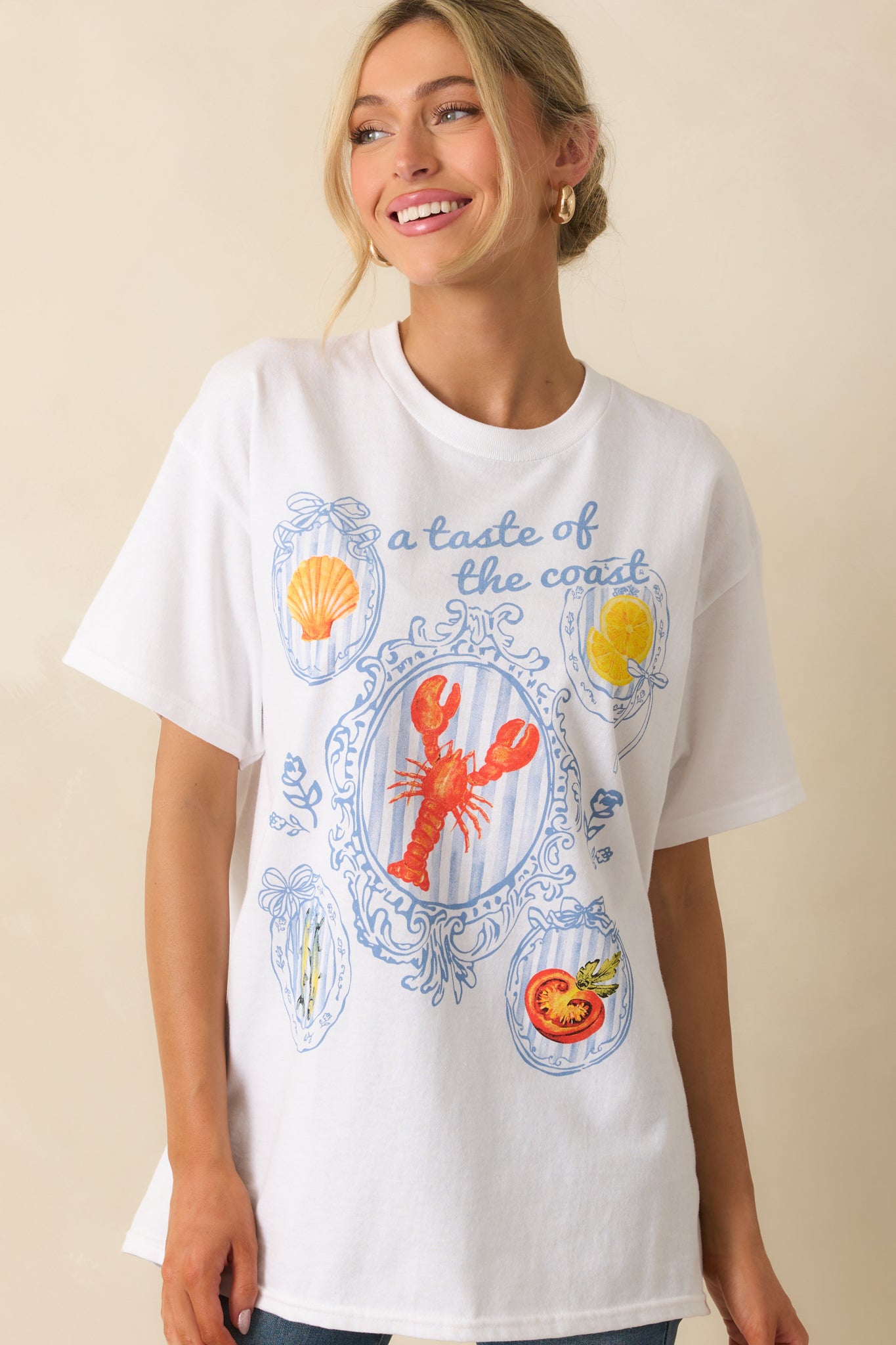 Front crop emphasizing the tee’s short sleeves and the colorful coastal print pattern across the fabric.