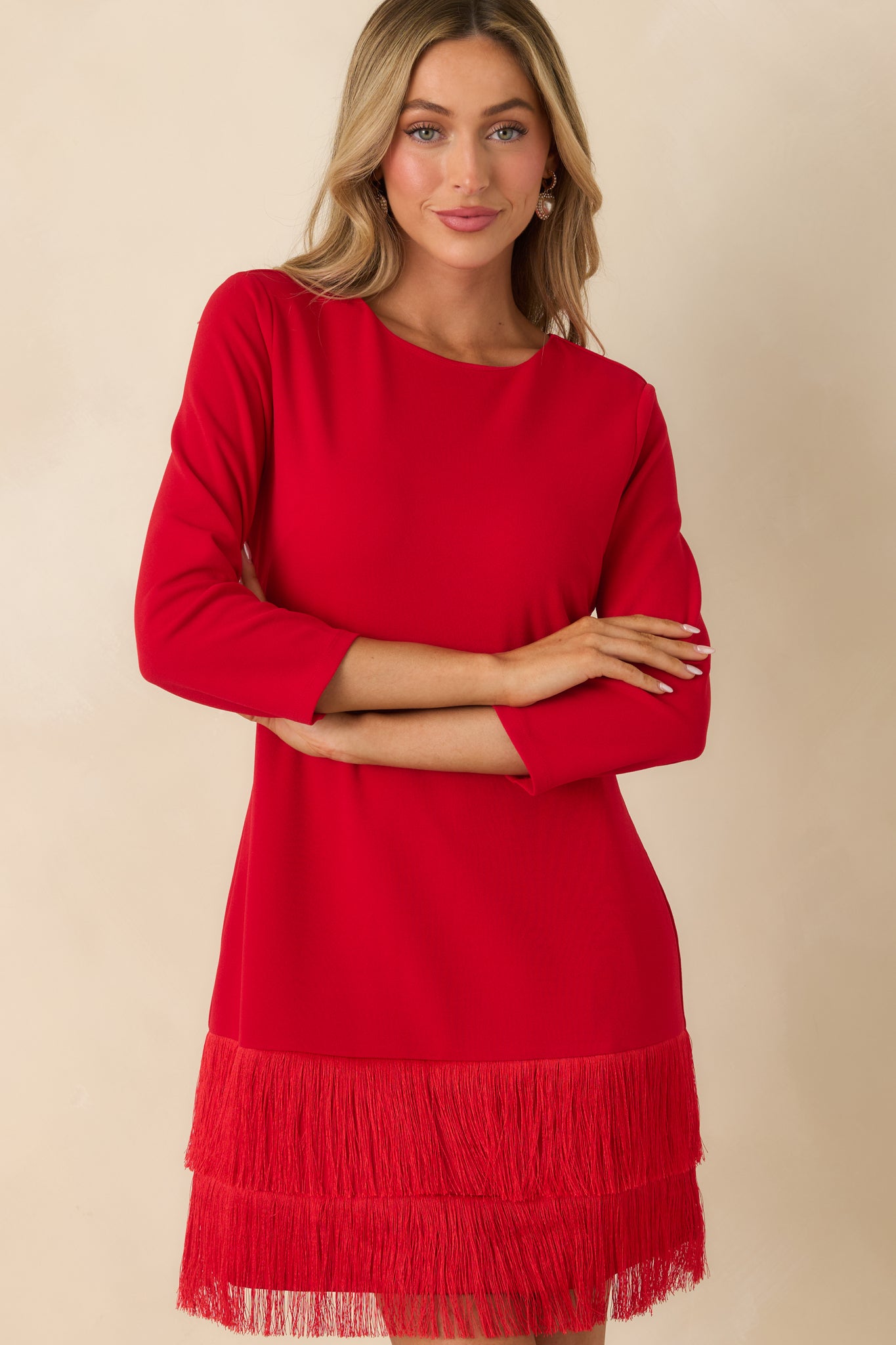 Front-focused crop showcasing the dress’s woven fabric, sleeve seam, and fringe layering at the hem.