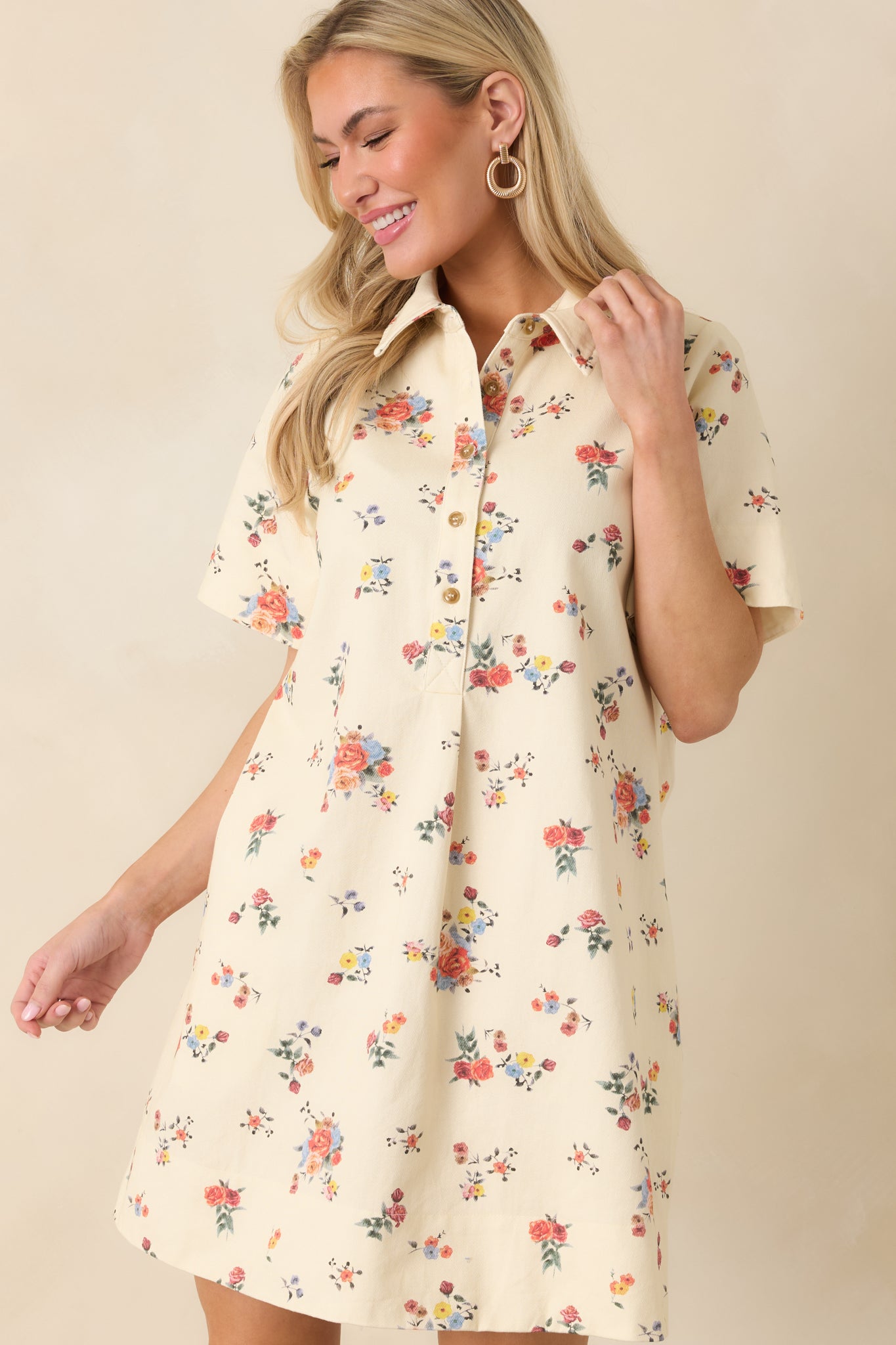 Front detail of cream mini dress emphasizing the short sleeves and side pocket construction.