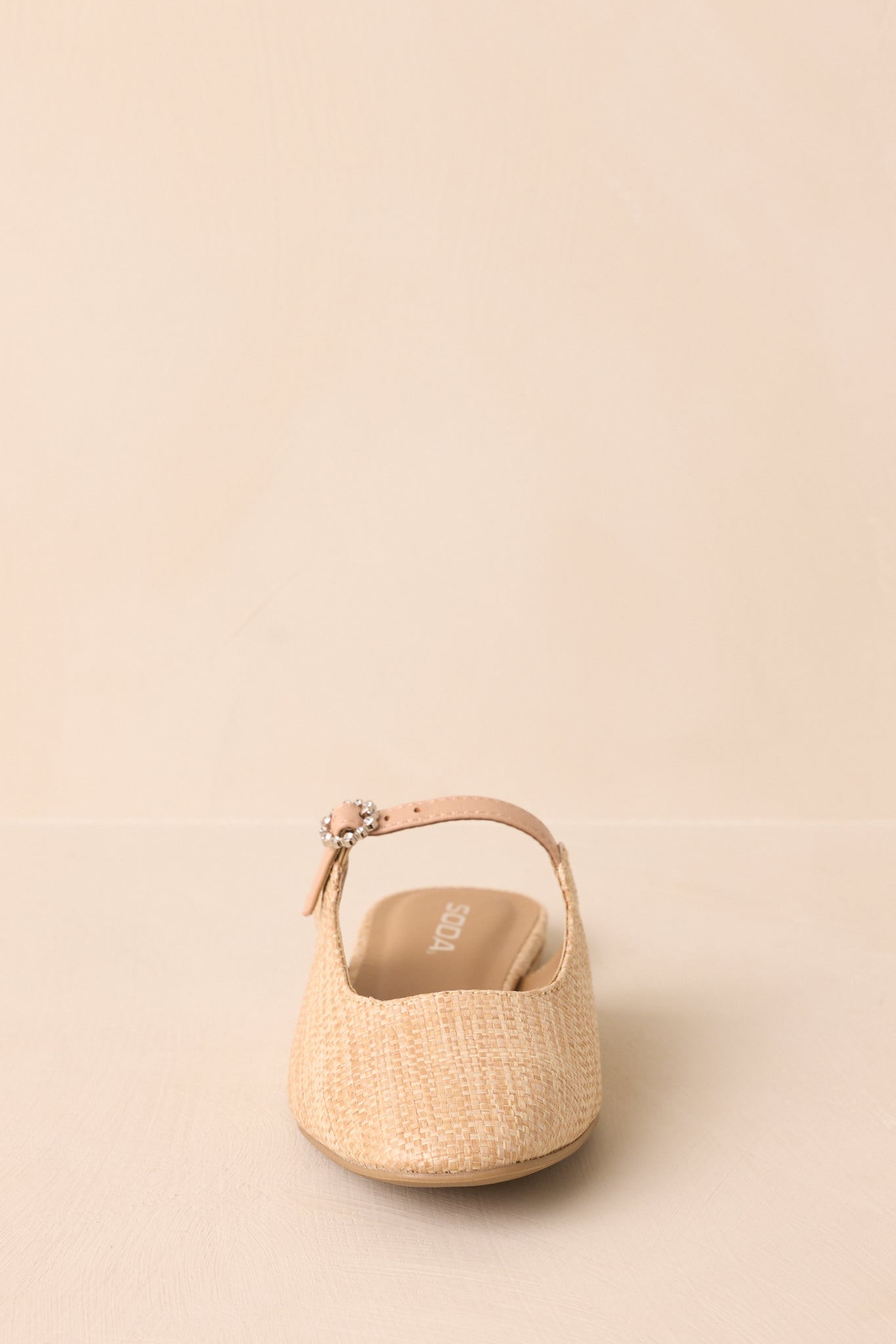 Front view of the raffia sandals displayed on a beige background showing the rounded toe and woven design.