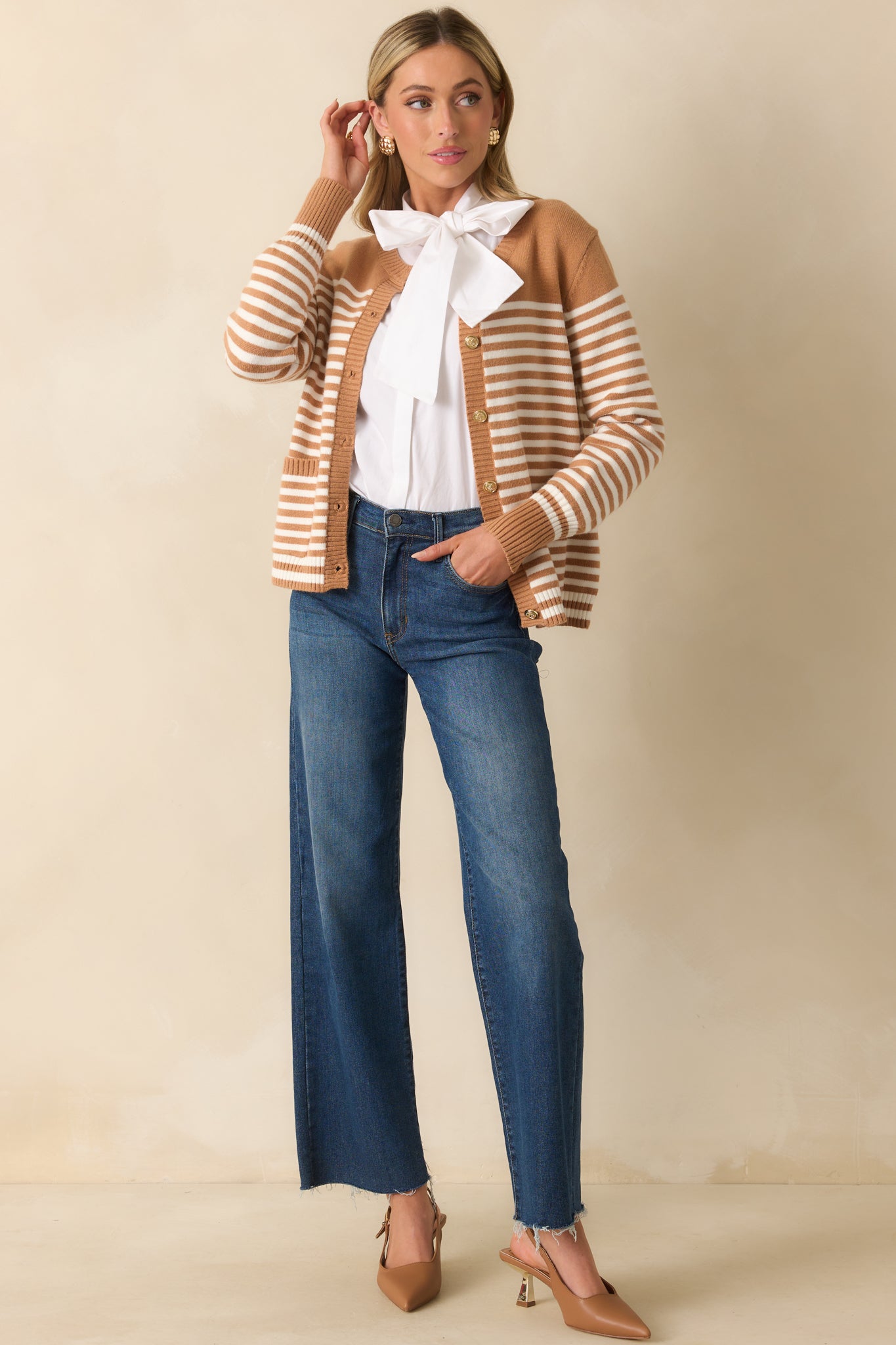 Front-facing angle highlighting the long sleeves, button front, and striped pattern of the camel brown cardigan.