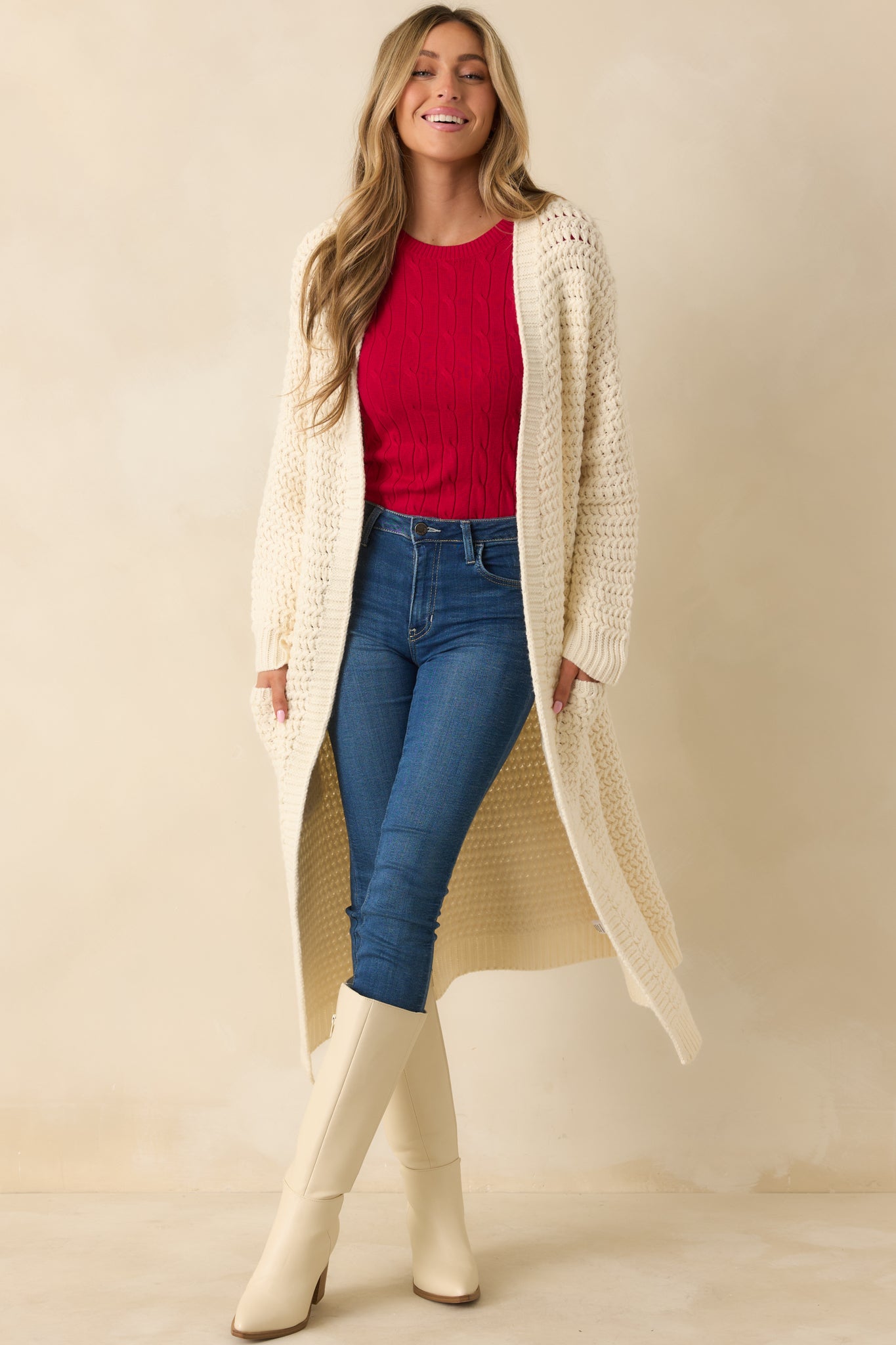 Front-facing cream cardigan highlighting chunky textured knit, patch pockets, and ribbed sleeve cuffs.