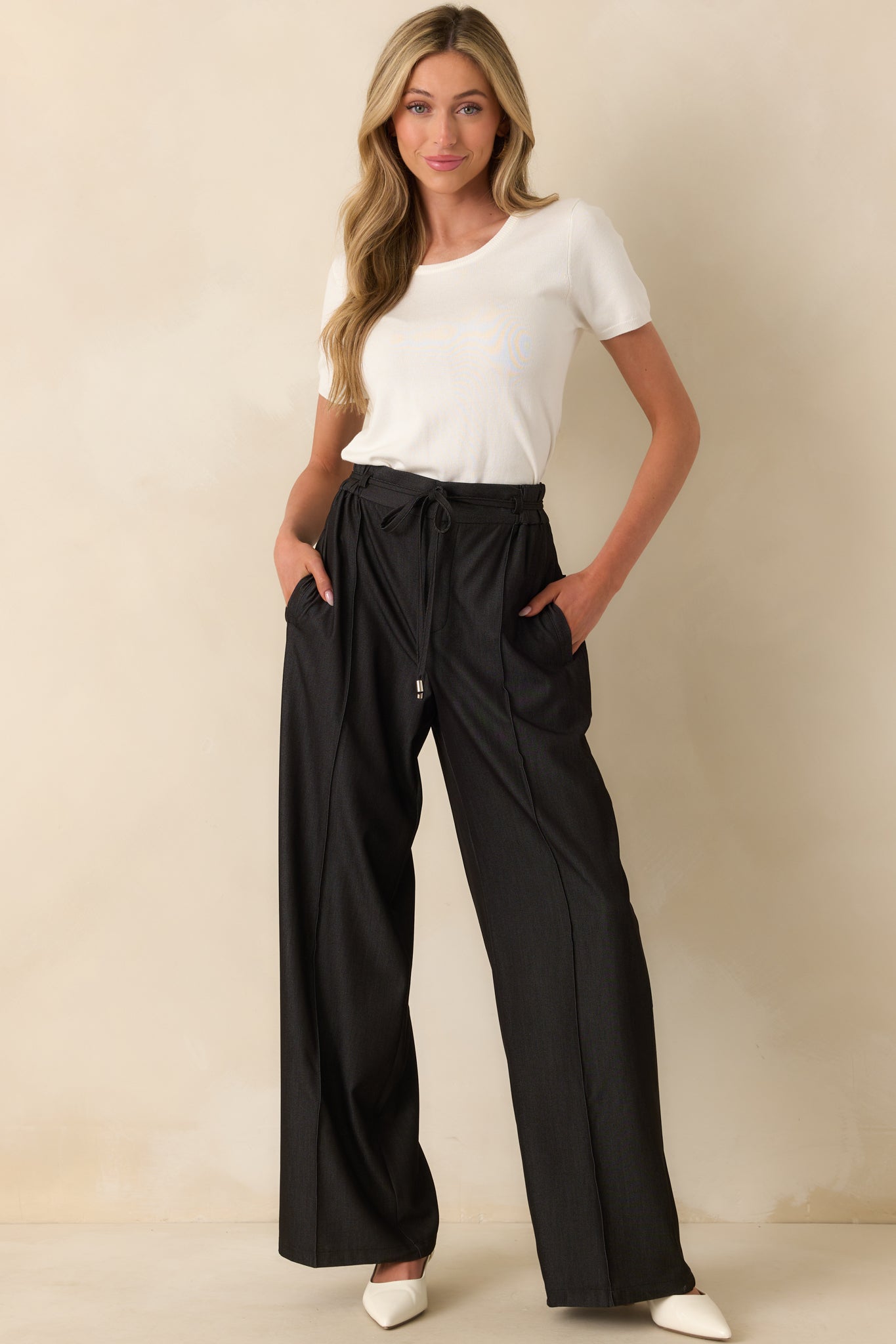 Front-facing full body view of the black pants showing the high rise waist, slim silhouette, and functional front pockets.