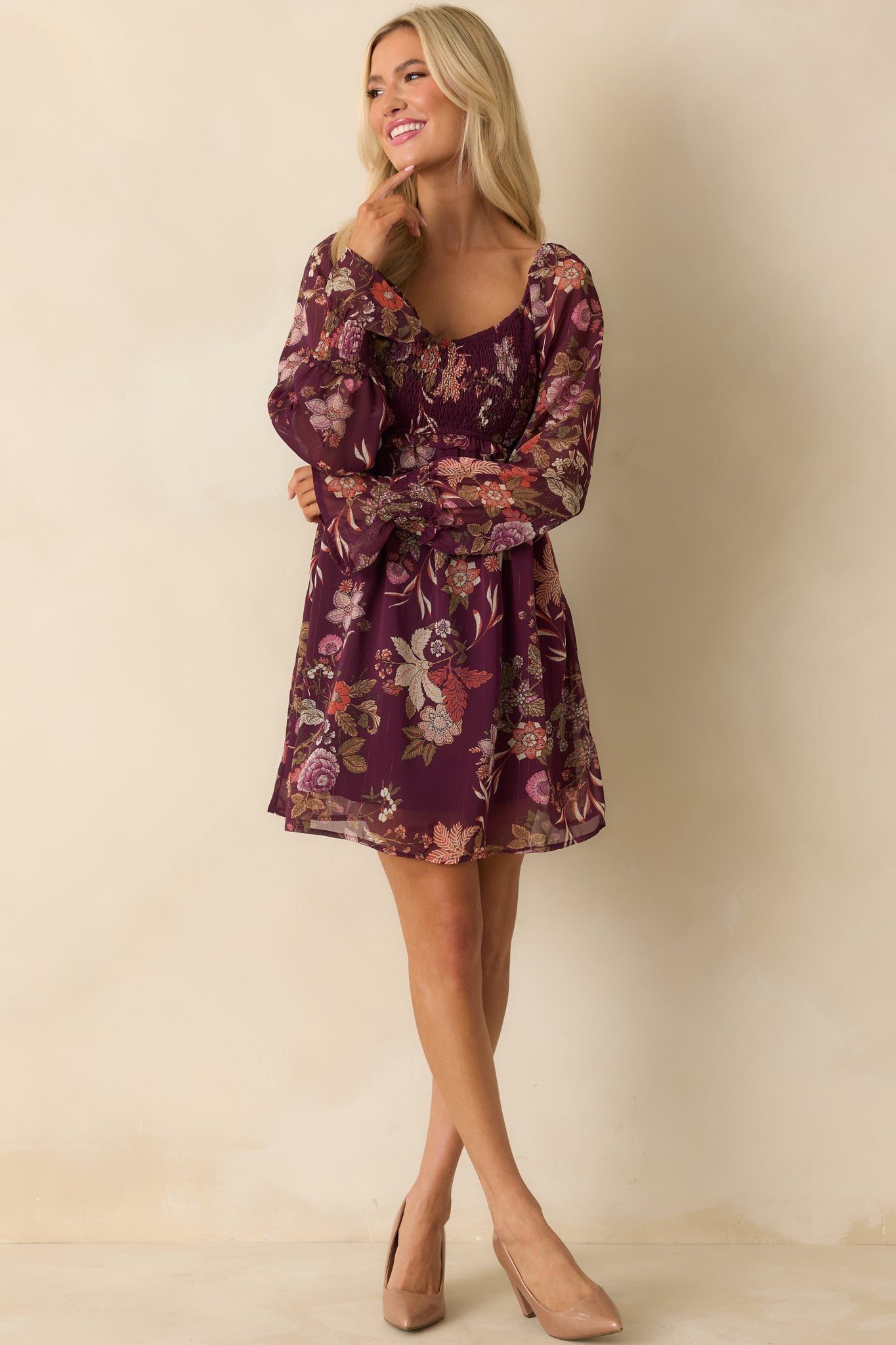 Front-facing mini dress featuring smocked waist, flowing A-line skirt, and floral pattern.